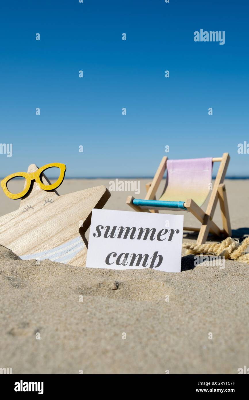 Testo DEL CAMPO ESTIVO su un biglietto d'auguri di carta sullo sfondo del salotto delle sedie a sdraio, stelle marine, decorazioni per le vacanze estive. Solarium sulla spiaggia sabbiosa Foto Stock