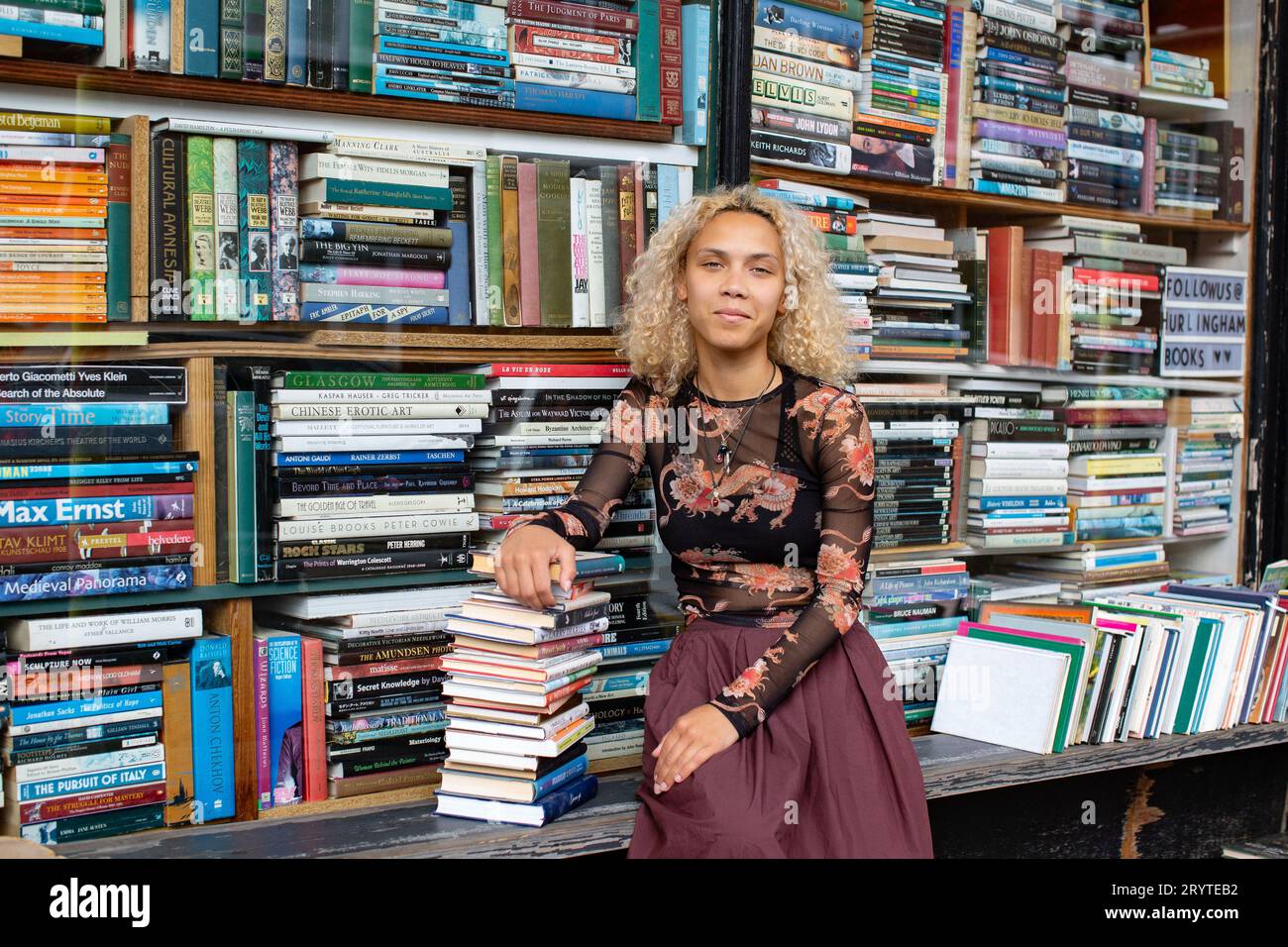 GREAT BRITAN / Londra / Hurlingham Books / attraente donna che tiene una pila di libri. Foto Stock