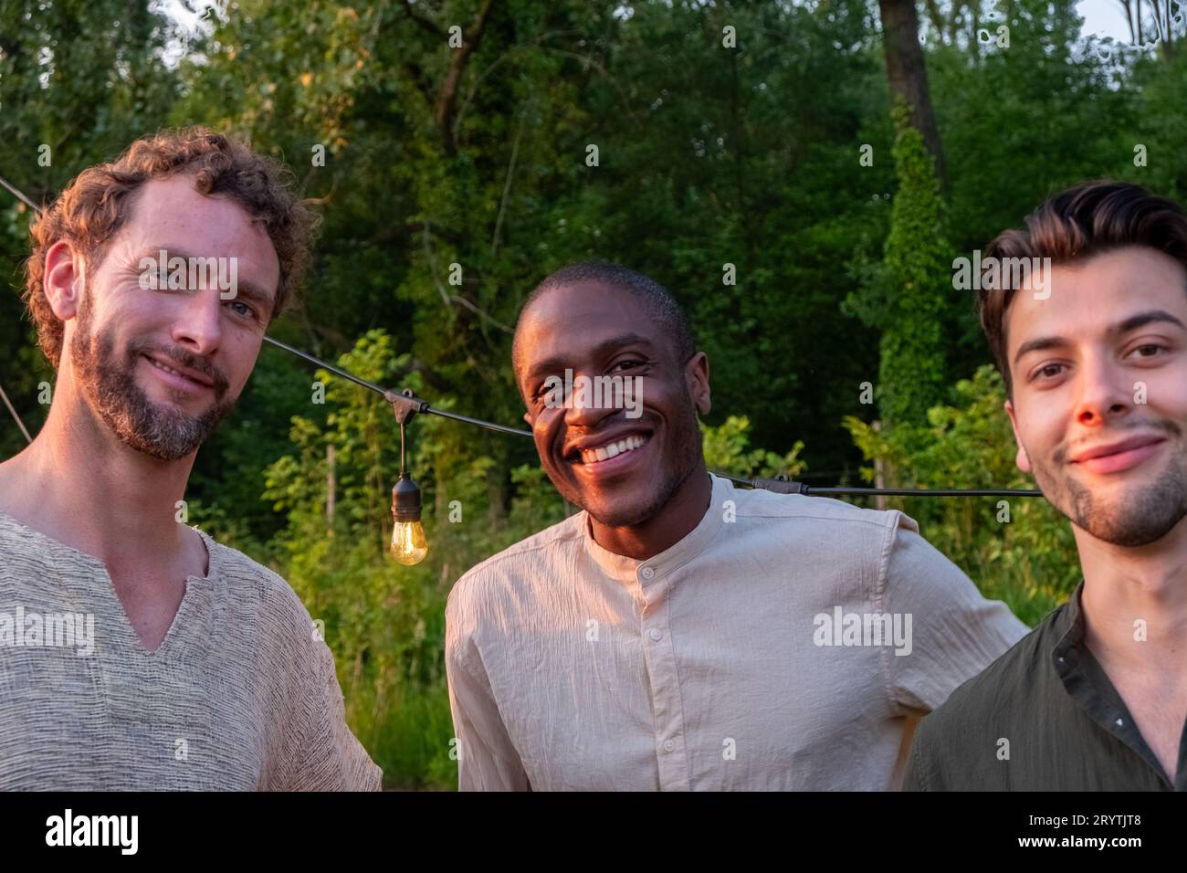 Legami di amicizia: Tre uomini multiculturali che abbracciano la diversità Foto Stock