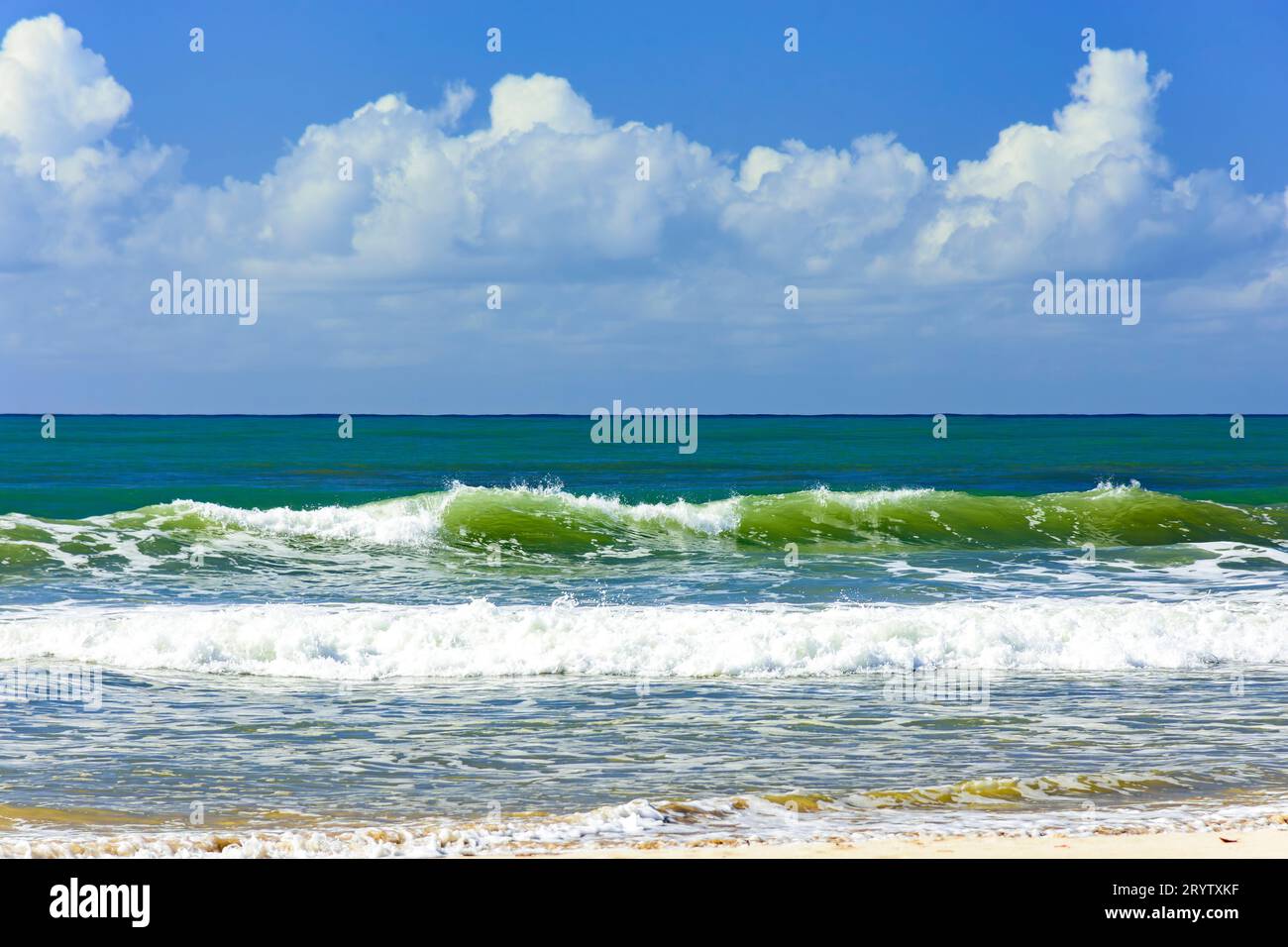 Piccole onde sulla riva in una soleggiata giornata estiva Foto Stock