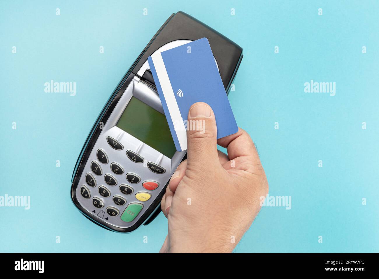 Effettua il pagamento a mano con carta di credito con tecnologia NFC contactless sul dispositivo terminale. Sfondo blu Foto Stock