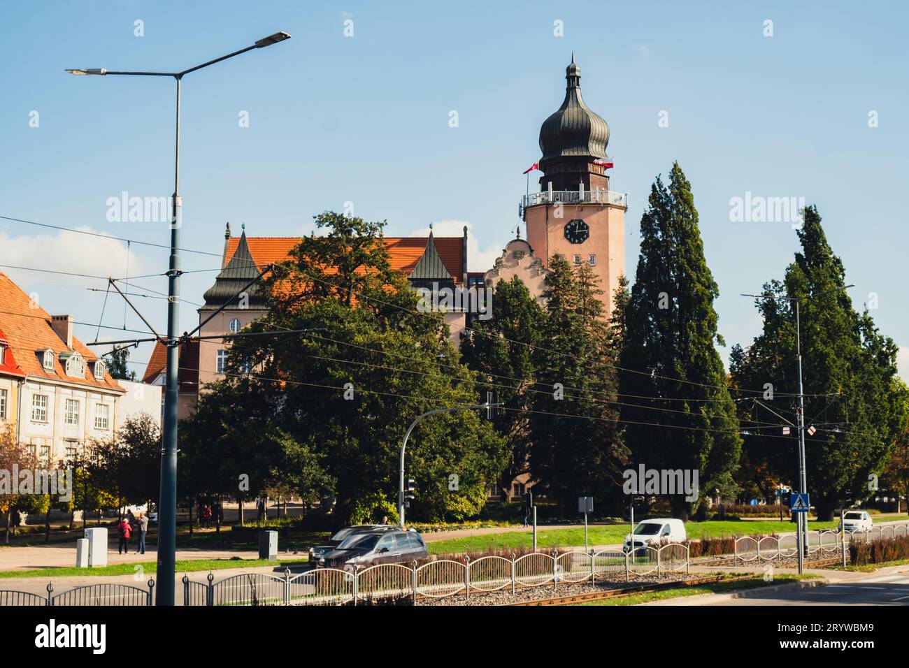 Veduta dell'Ufficio governativo della città di Elblag attraverso gli alberi verdi. Bandiere polacche sul vento. Viaggi Foto Stock