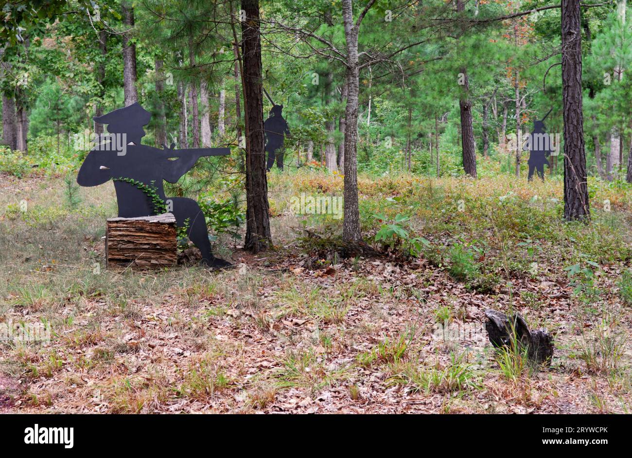 La foto mostra la silhouette dei soldati coloniali con i fucili sul sentiero escursionistico del Kings Mountain National Military Park, South Carolina USA. Foto Stock