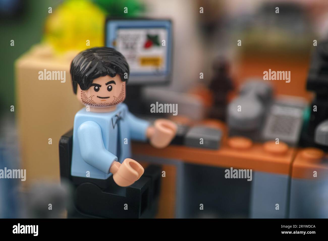 Tambov, Federazione Russa - 30 settembre 2023 Una minifigura di un uomo d'affari Lego seduto su una sedia dietro un computer in un ufficio e guardando la telecamera Foto Stock