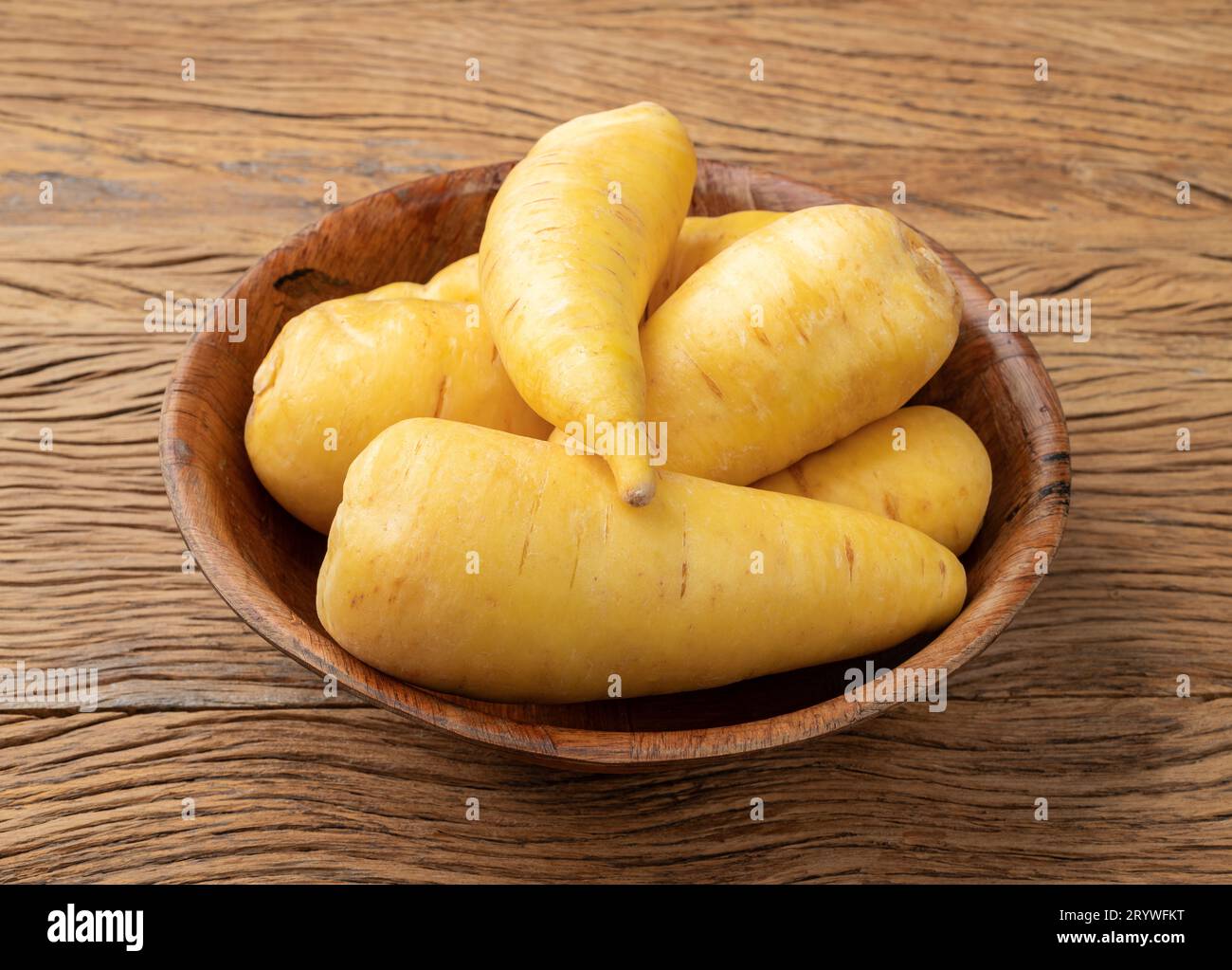Mandiochinha crudo o arracacha in una ciotola su tavola di legno. Foto Stock