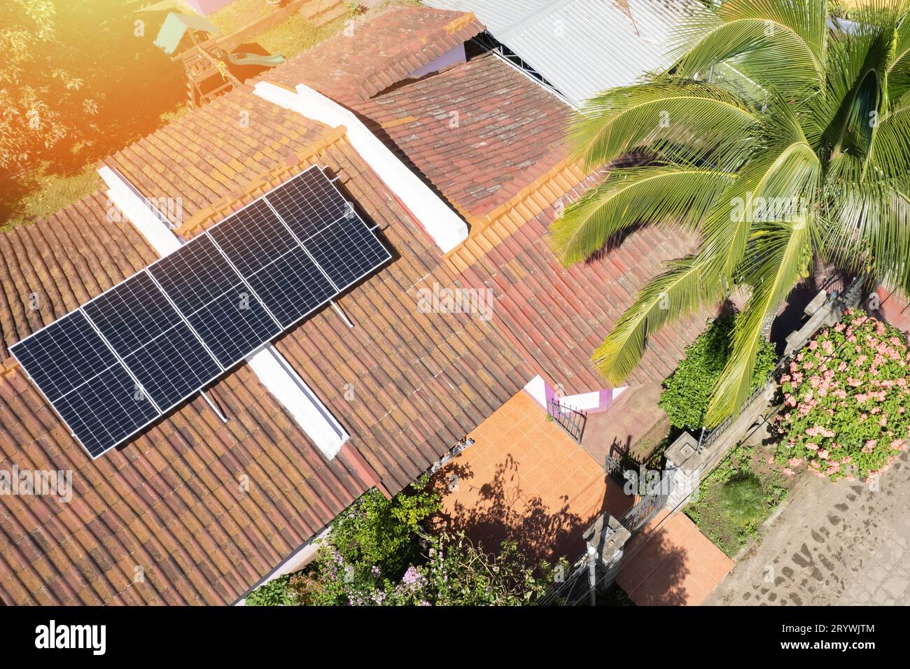 Sistema di pannelli solari sul tetto della casa con vista droni superiore nelle giornate di sole Foto Stock