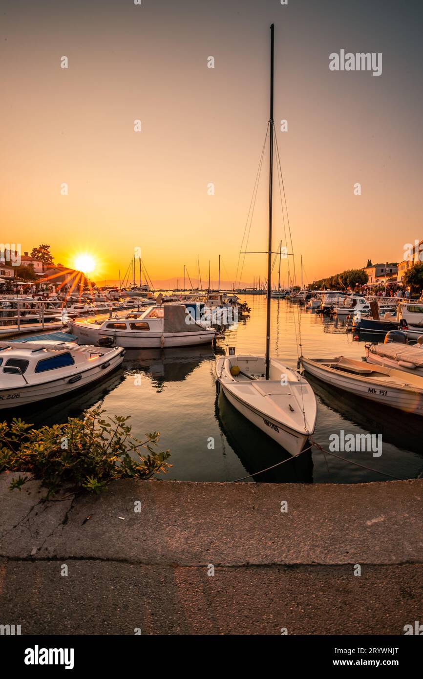 Accattivante bagliore serale al porto di Krk: Tramonto sull'isola delle vacanze in Istria, Croazia Foto Stock