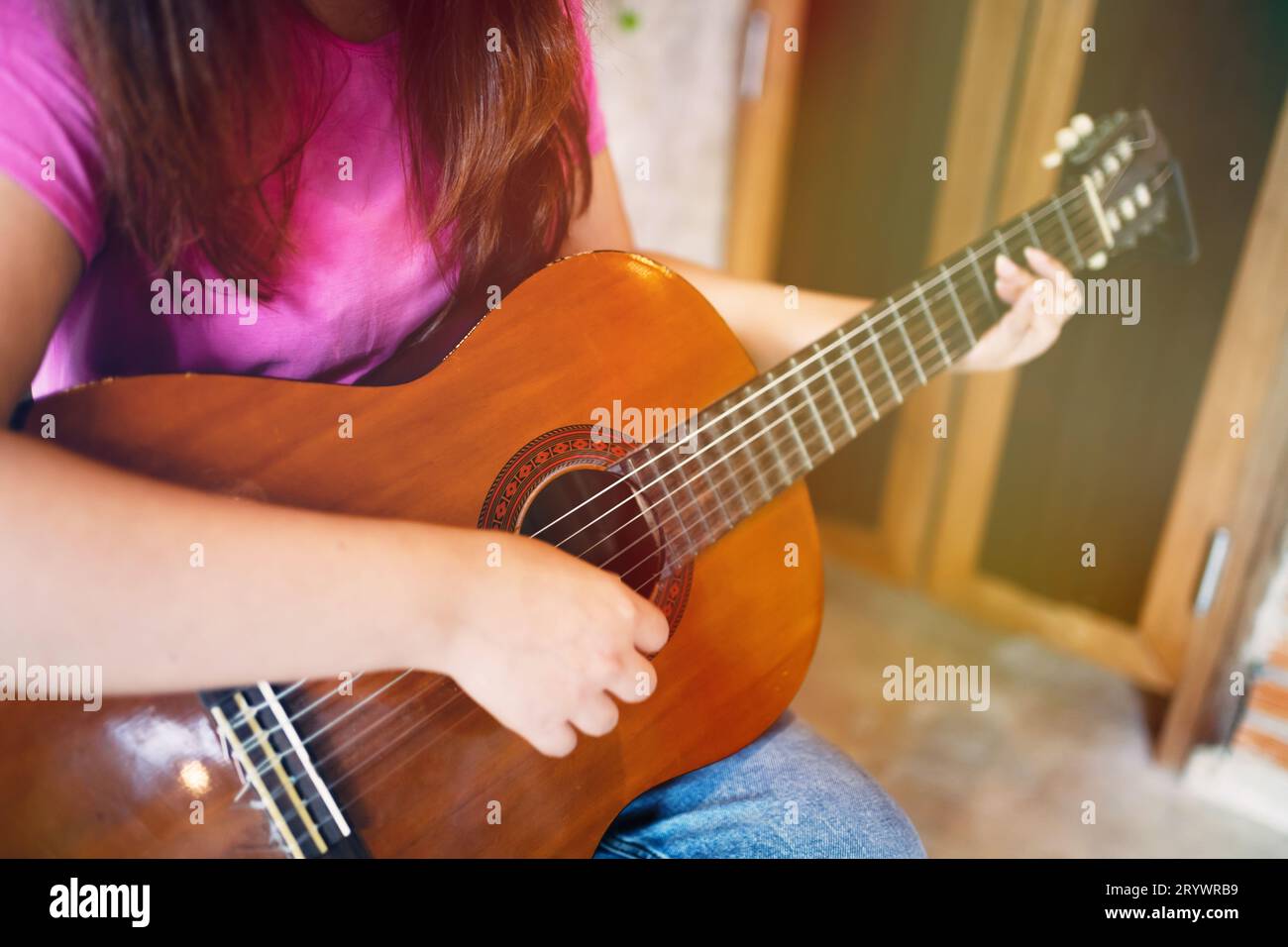 Le mani di una giovane donna felice che suona la chitarra acustica Â solo compongono una lezione strumentale songÂ suonare la chitarra Foto Stock