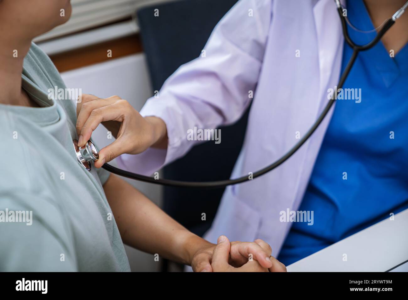 Medico sanitario. Medico professionista in bianco uniforme camice intervista intervista paziente rassicurante il suo paziente maschio Foto Stock
