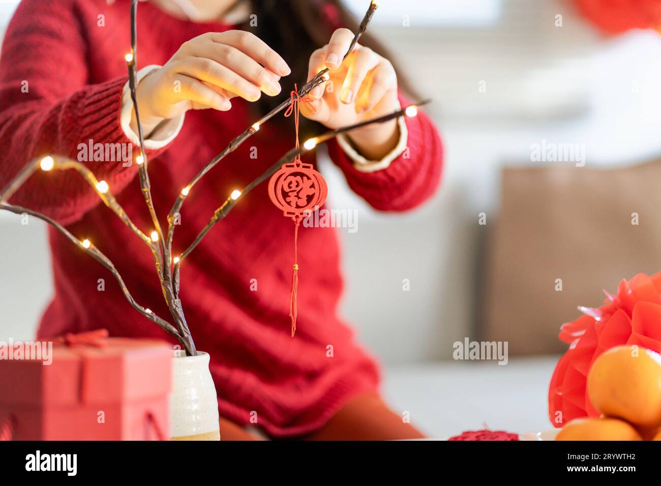 Casa decorata da donna asiatica per le celebrazioni del capodanno cinese. Un ciondolo tradizionale per il Capodanno lunare cinese per goo Foto Stock