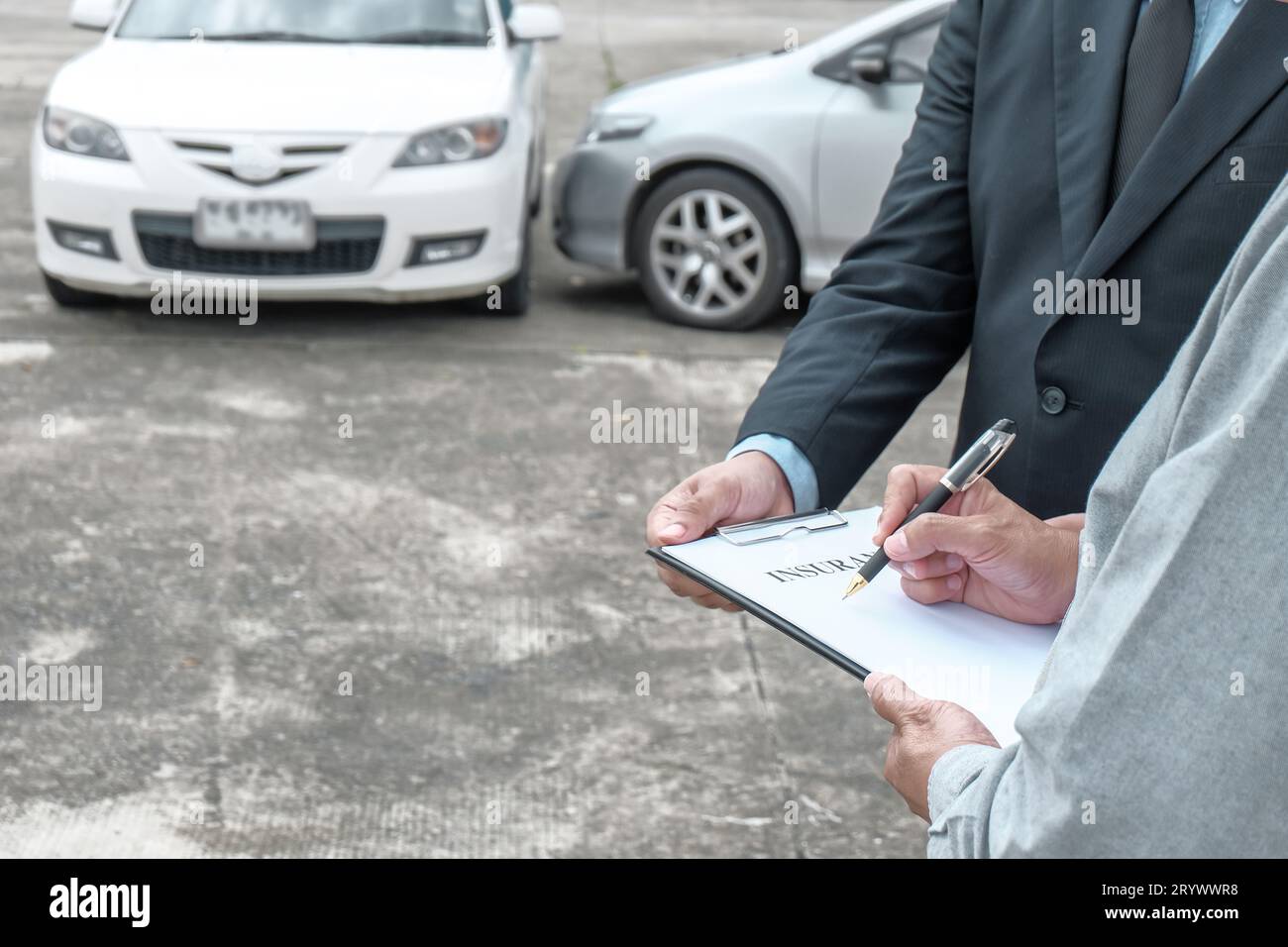 Agente assicurativo del registro delle perdite che ispeziona la vettura danneggiata. Il responsabile delle vendite fornisce un documento di richiesta di consulenza che valuta l'offerta di mutui ipotecari per l'acquisto di autoveicoli Foto Stock