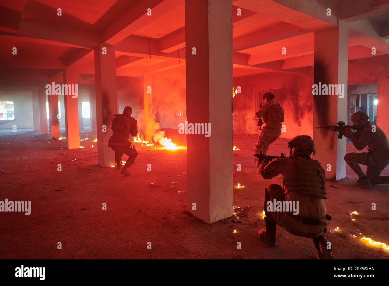 Un gruppo di soldati professionisti esegue coraggiosamente una pericolosa missione di salvataggio, circondata dal fuoco in un edificio pericoloso. Foto Stock