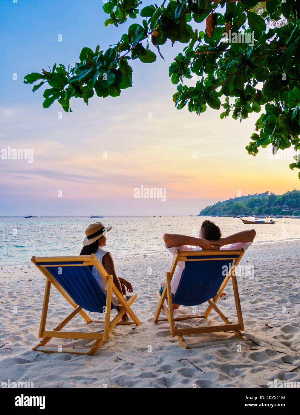 Coppia che si rilassa su una sdraio sulla spiaggia di Koh Lipe in Thailandia Foto Stock