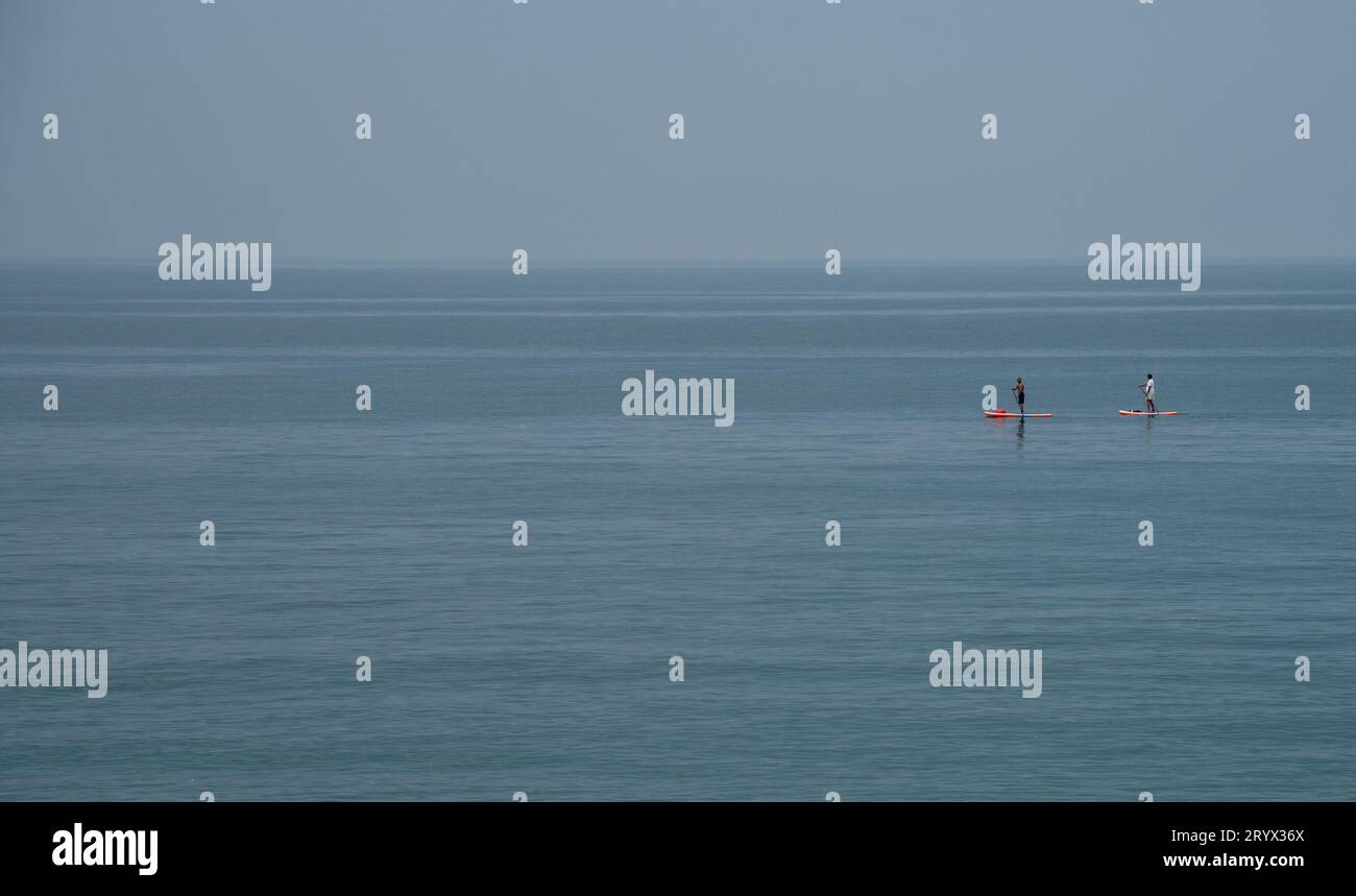 Gente non riconosciuta che canoa nel mare la mattina. Persone che si esercitano nell'oceano Foto Stock