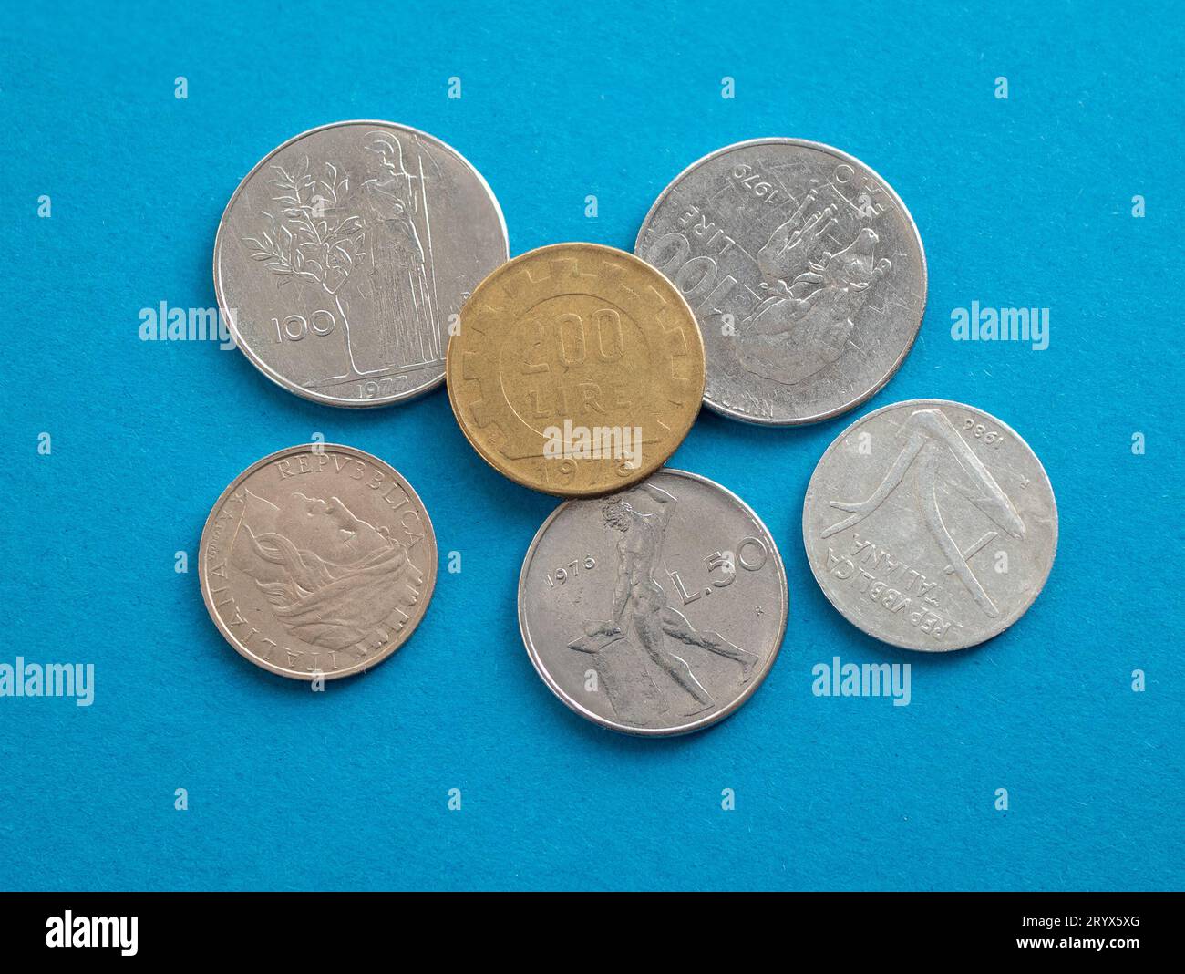 Monete italiane prima dell'euro, primo piano. Monete in lira antica italiana su sfondo blu Foto Stock