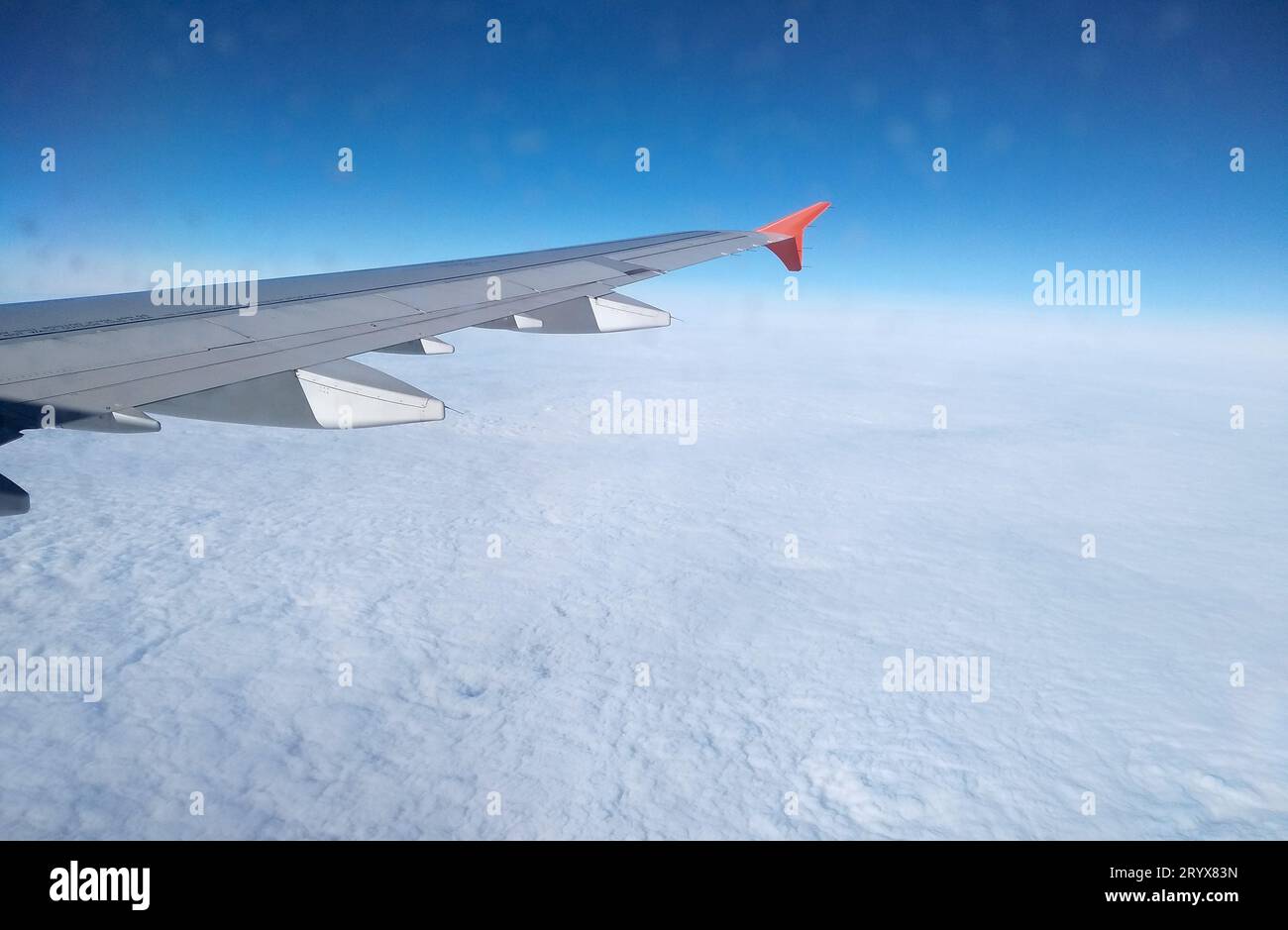 Aereo in volo. Persone che viaggiano. Vista aerea dalla finestra dell'aereo. Cielo blu sopra le nuvole Foto Stock