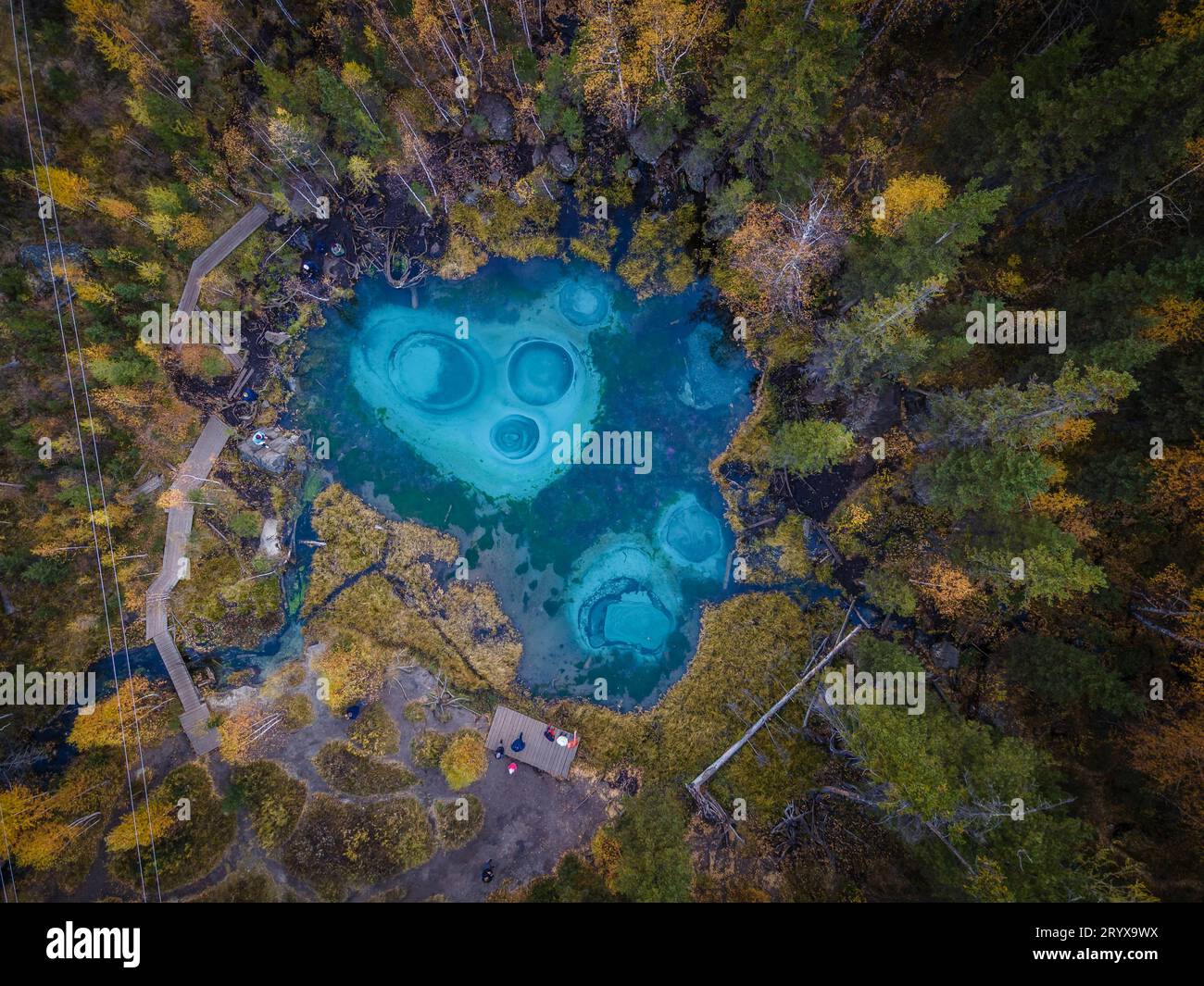 Il bellissimo piccolo lago con acque turchesi nel mezzo della foresta delle montagne Altai, Siberia, Russia (foto aerea). Foto Stock