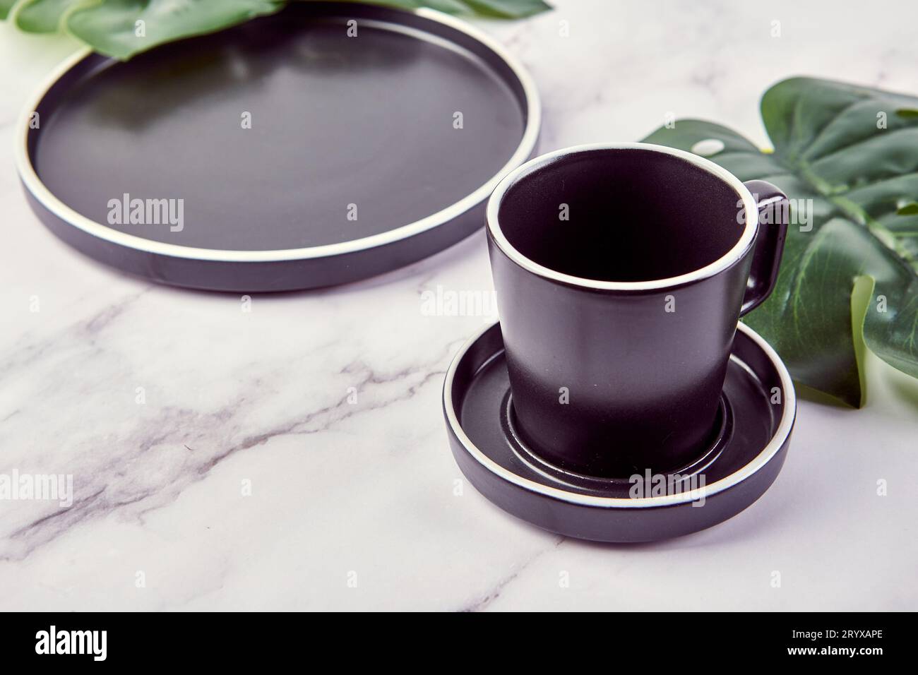 Set di piatti moderni e alla moda e tazza da caffè su sfondo di marmo. Foto Stock