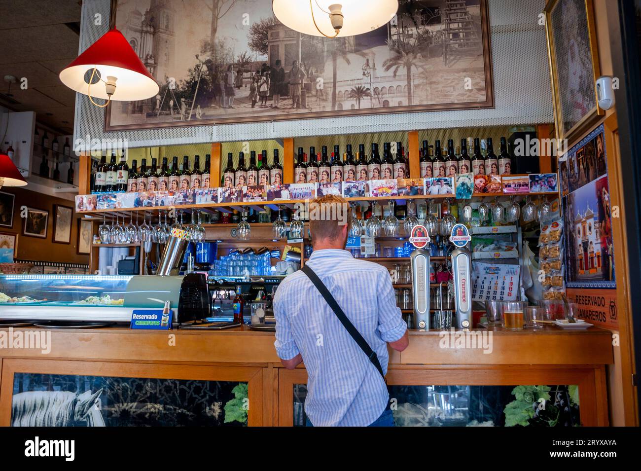 Siviglia Spagna, uomo in piedi da dietro, Bar locale interno, birra, nel centro città, alcol salute pubblica Foto Stock