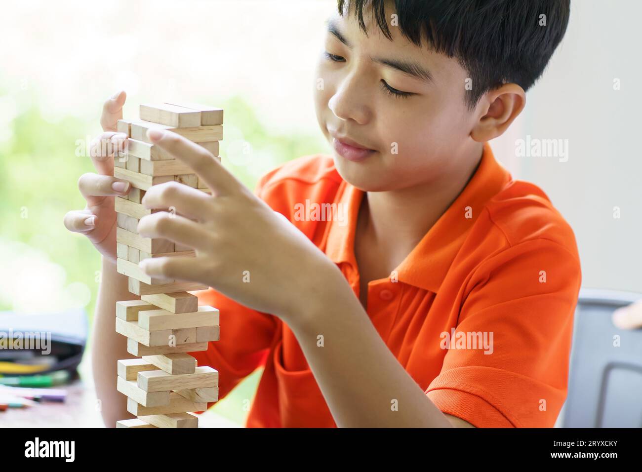 Padre e figlio asiatici che giocano a blocchi di legno bambino Carefree che gioca a blocchi di legno costruttore di costruzioni di blocchi di legno da blocchi con padre Foto Stock