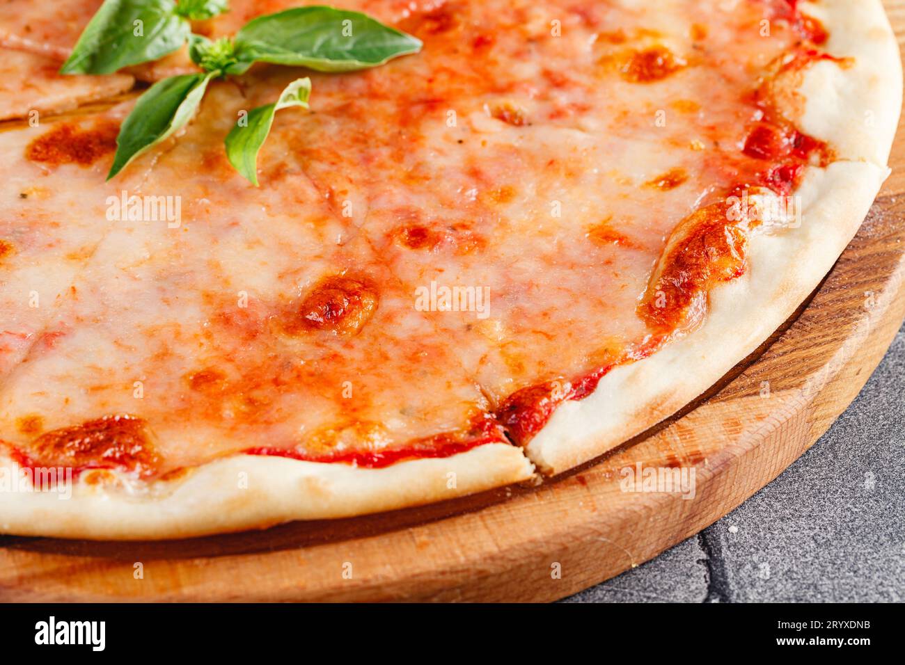 Pizza margarita su tavola di legno su sfondo scuro. Primo piano Foto Stock