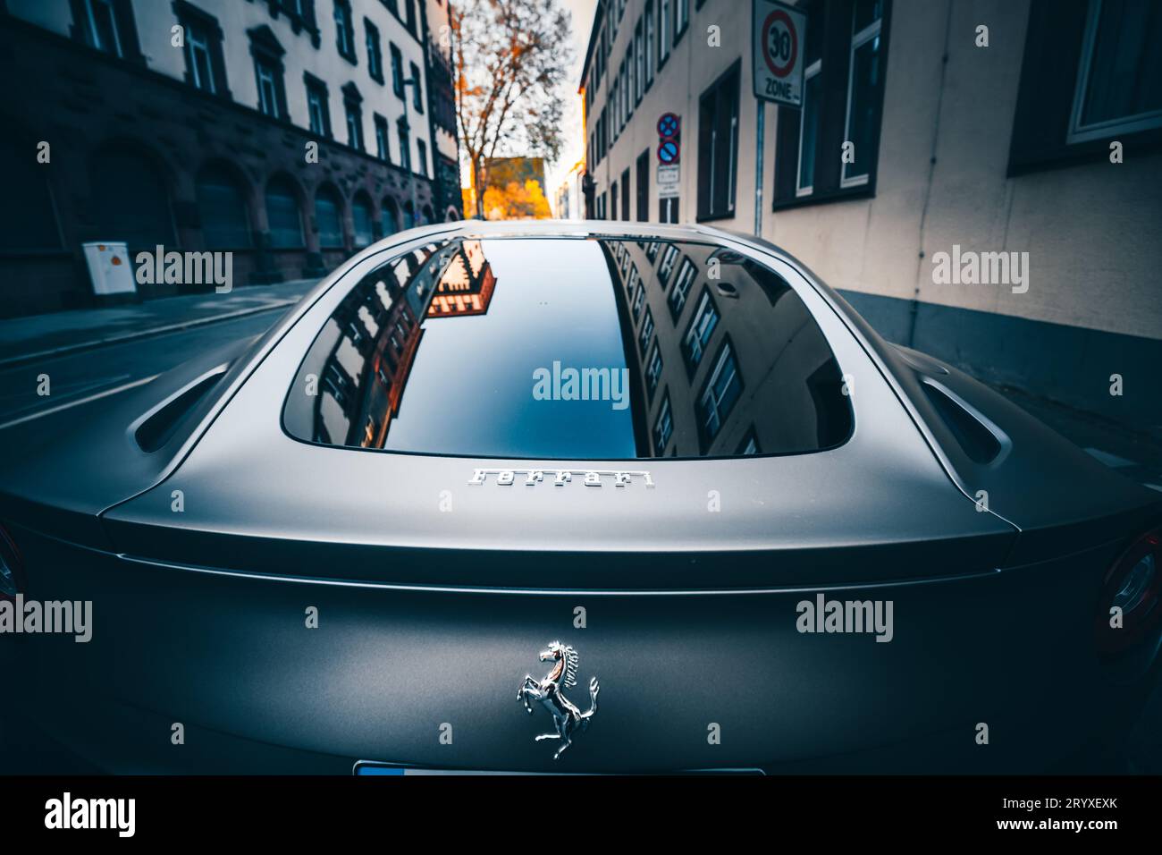 Eleganza su ruote: Mercedes in strada, riflesso degli edifici nelle luci di coda Foto Stock