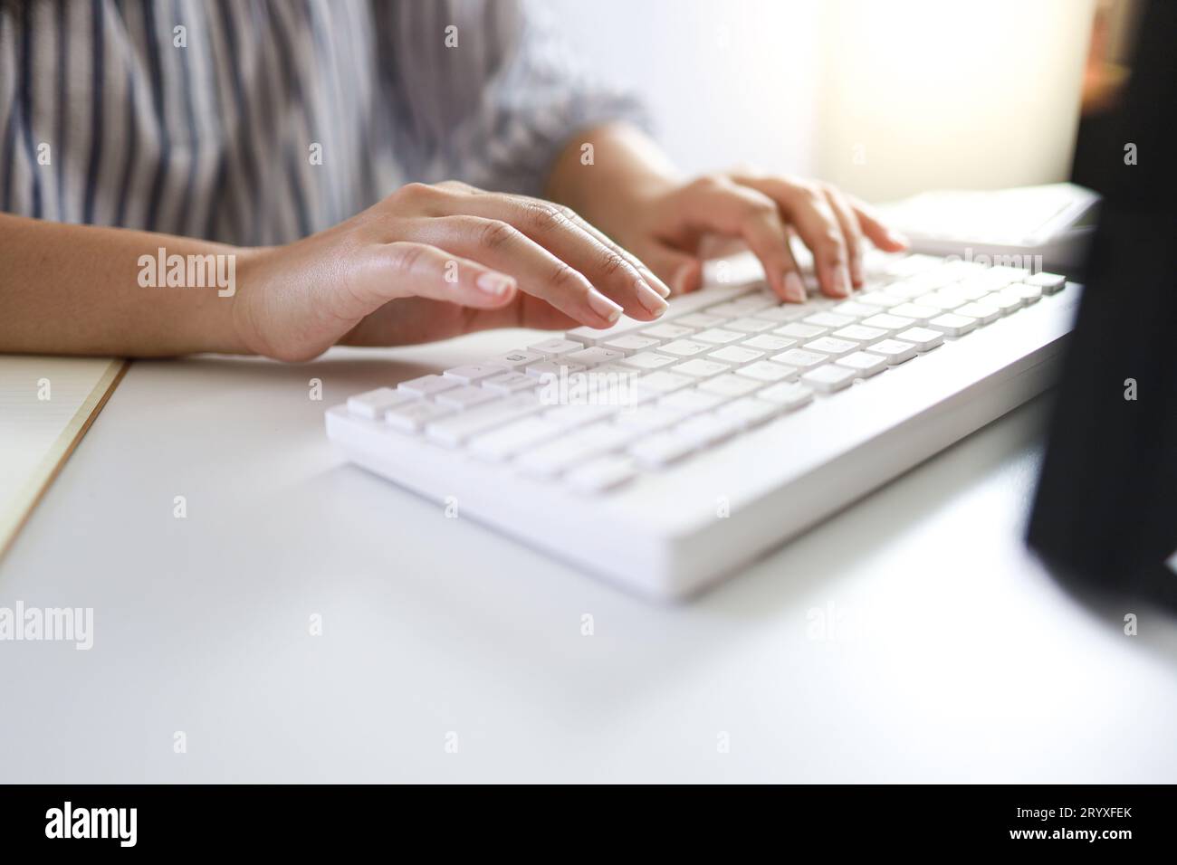 Mani che digitano sulla tastiera. scrivere un blog. Una donna che lavora a casa con le mani sulla tastiera Foto Stock