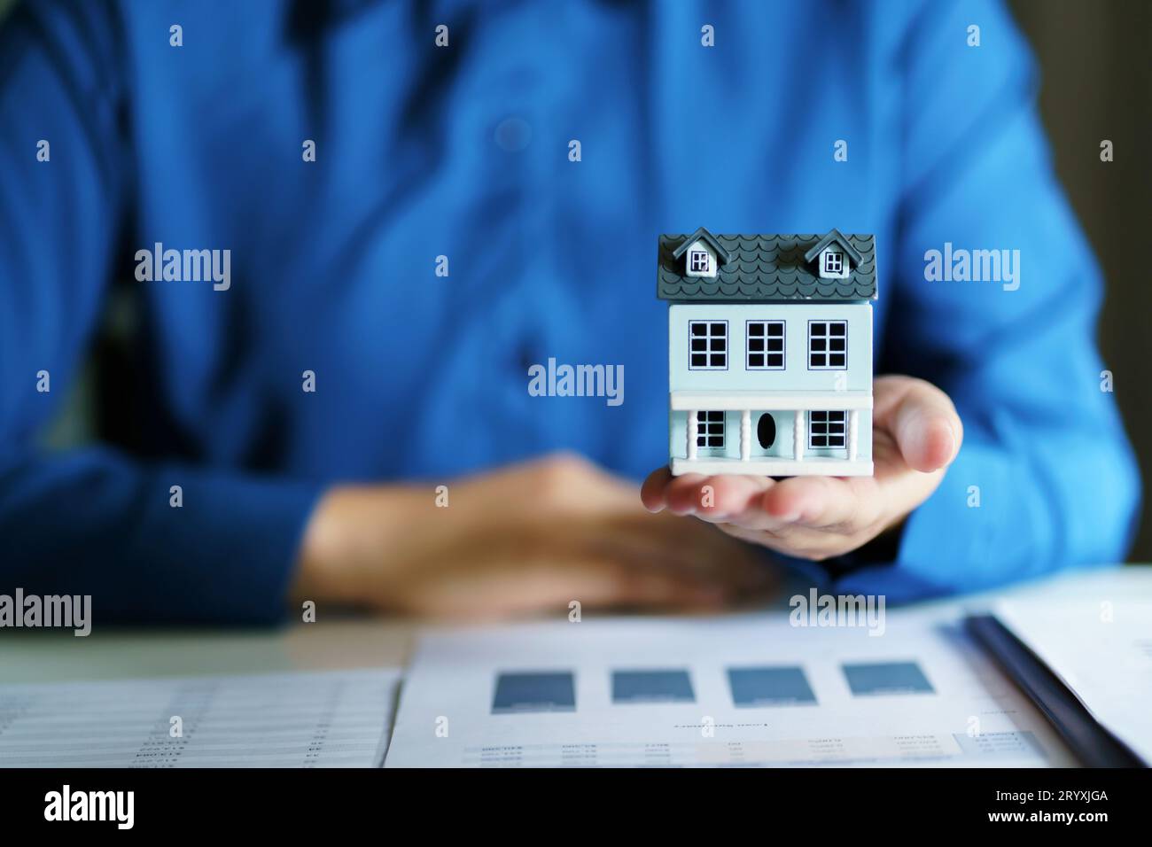 Assicurazione e sicurezza immobiliare per investimenti immobiliari. L'agente immobiliare offre la casa. Foto Stock