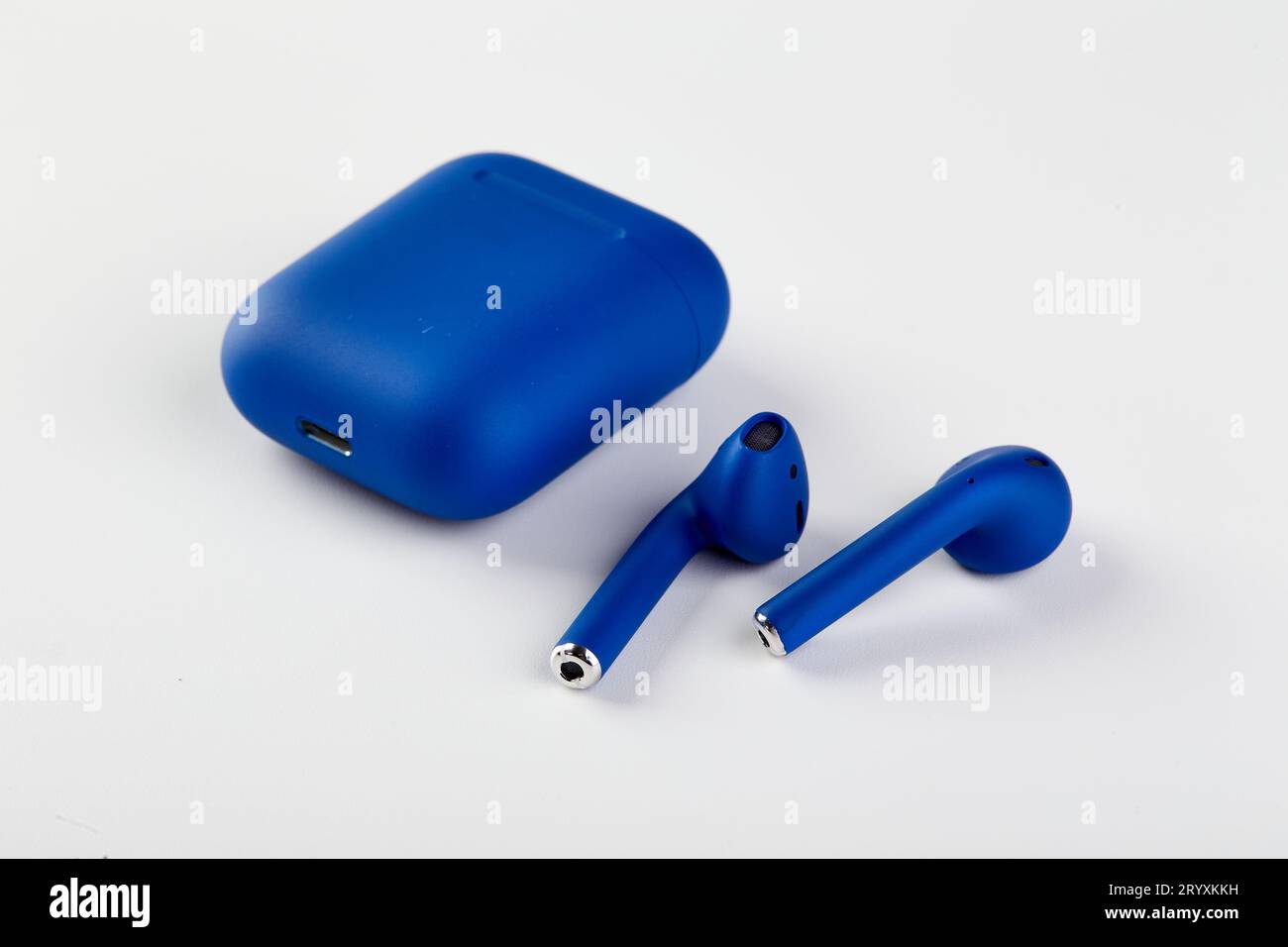 Nuove cuffie wireless blu nella custodia di ricarica primo piano su sfondo bianco. Foto Stock