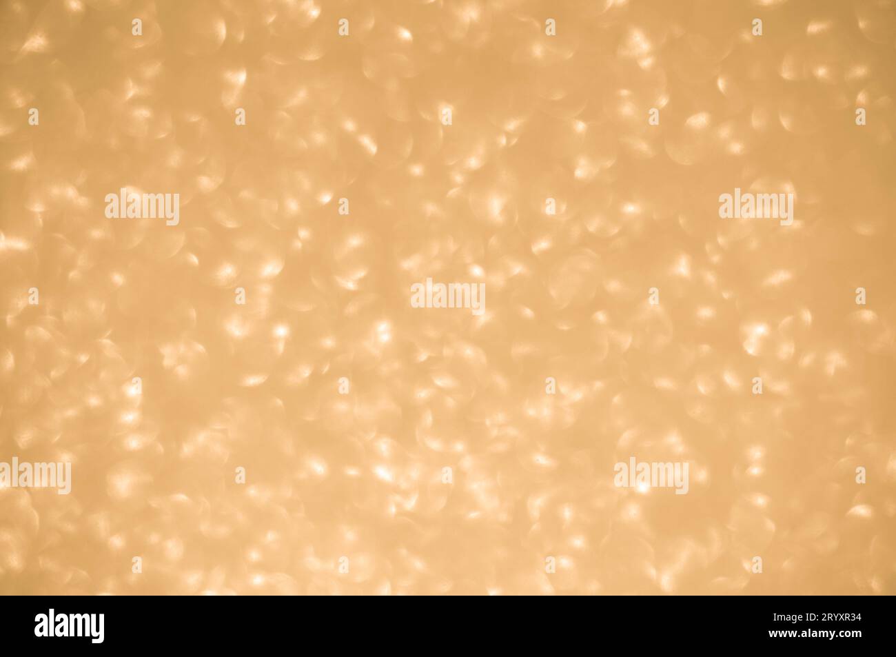 Sfondo dorato scintillante. Le luci spot sfocate scintillanti hanno una texture dorata brillante Foto Stock
