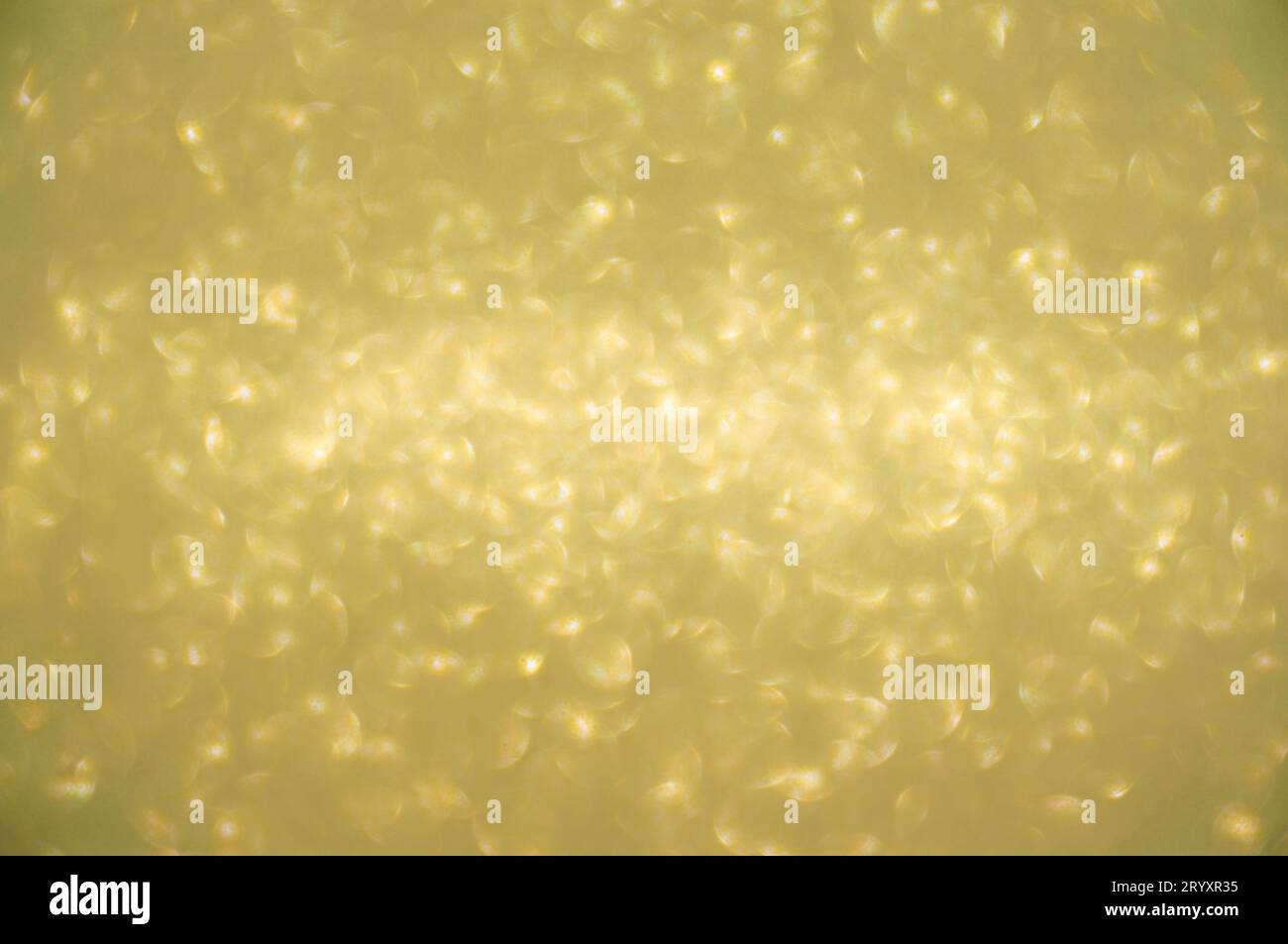 Sfondo dorato scintillante. Luci spot sfocate scintillanti sfondo luminoso oro brillante. Foto Stock