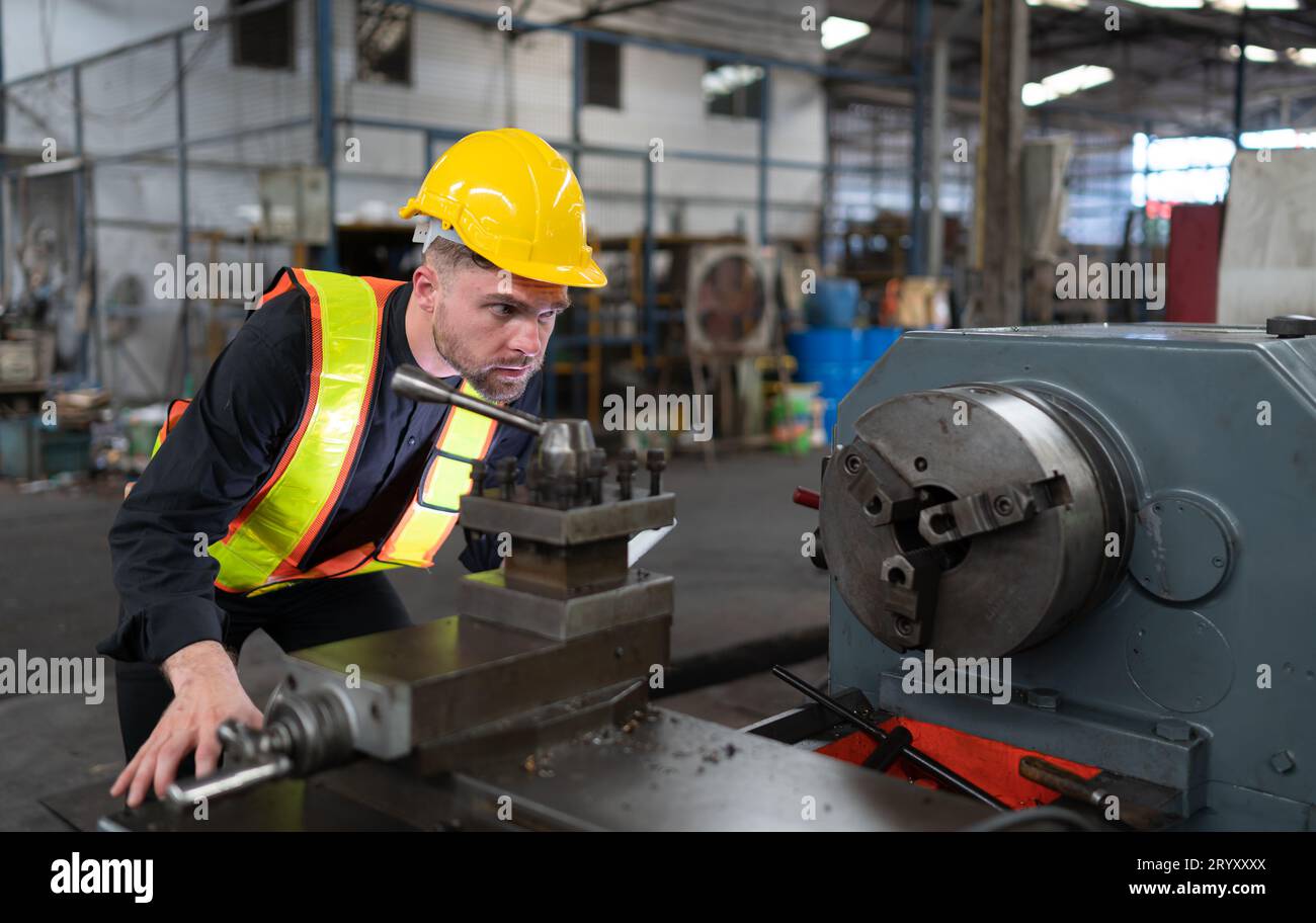 Gli ingegneri meccanici entrano nel vecchio magazzino di macchinari per ispezionare e riparare i macchinari usati con il personale del magazzino. Foto Stock