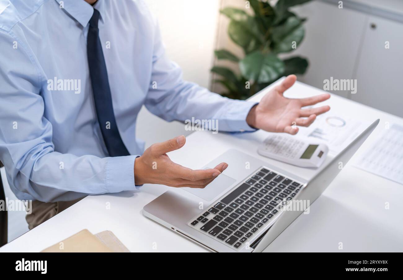 Chiamata VDO ConferenceÂ uomo lavora da casa. Parla chat online durante una videochiamata con la webcam del laptop ConferenceÂ uomo d'affari asiatico che lavora Foto Stock