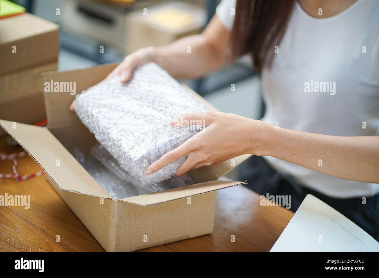 Donna asiatica che prepara la scatola di consegna del pacchetto spedizione per lo shopping consegna online servizio postale persone e concetto di spedizione Foto Stock