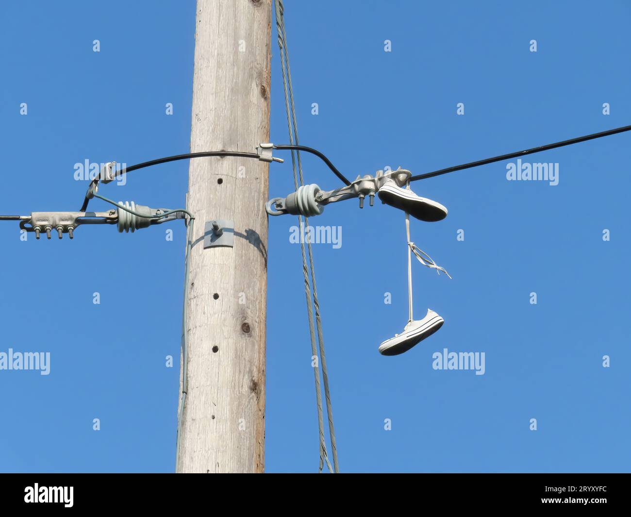 Sneakers sospese da Power Lines. Concetto: Messaggio segreto, shoefiti o lancio di scarpe Foto Stock