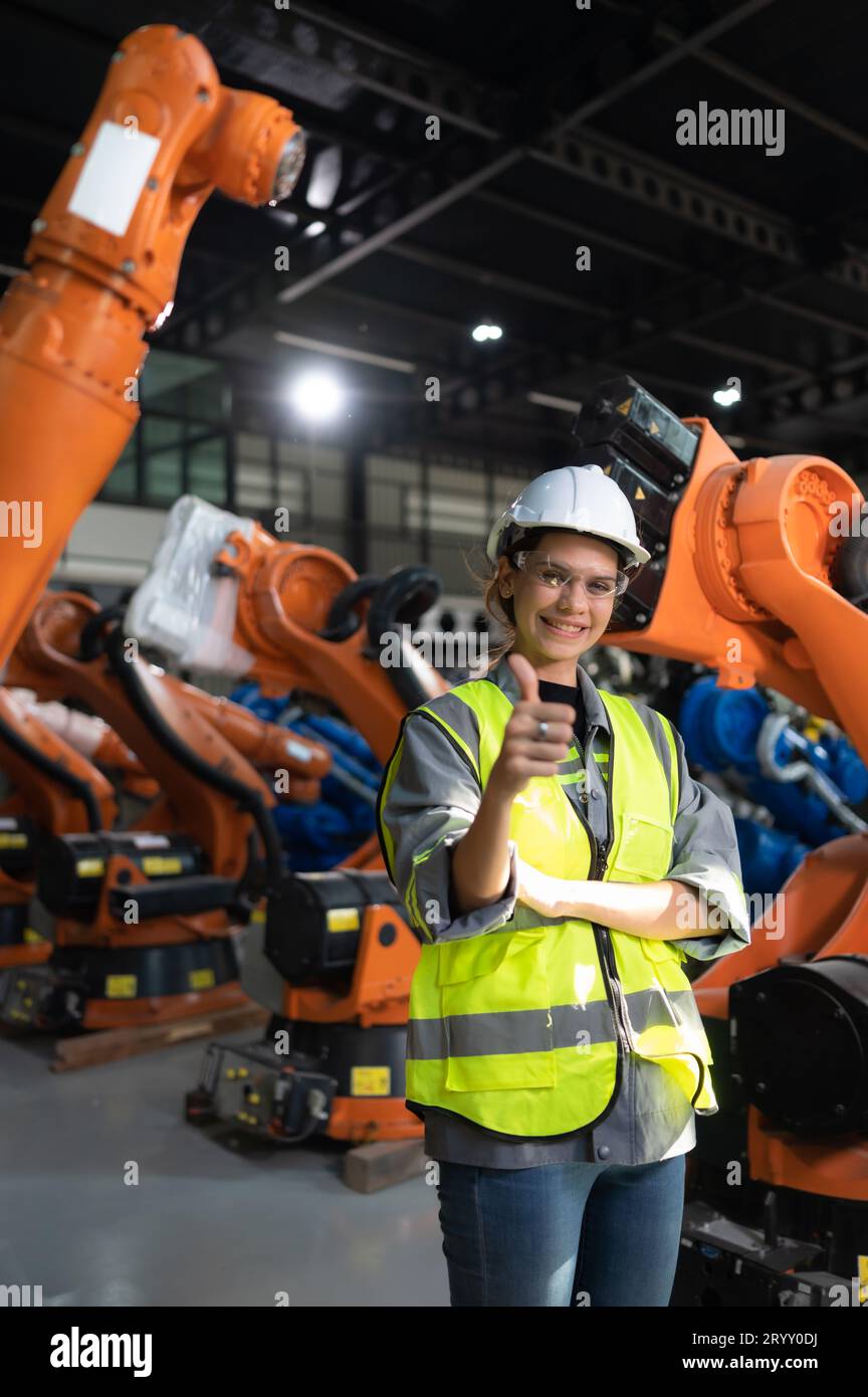 Ritratto di una donna ingegnere con la missione di controllare, testare, migliorare il software e calibrare il braccio robotico. Foto Stock