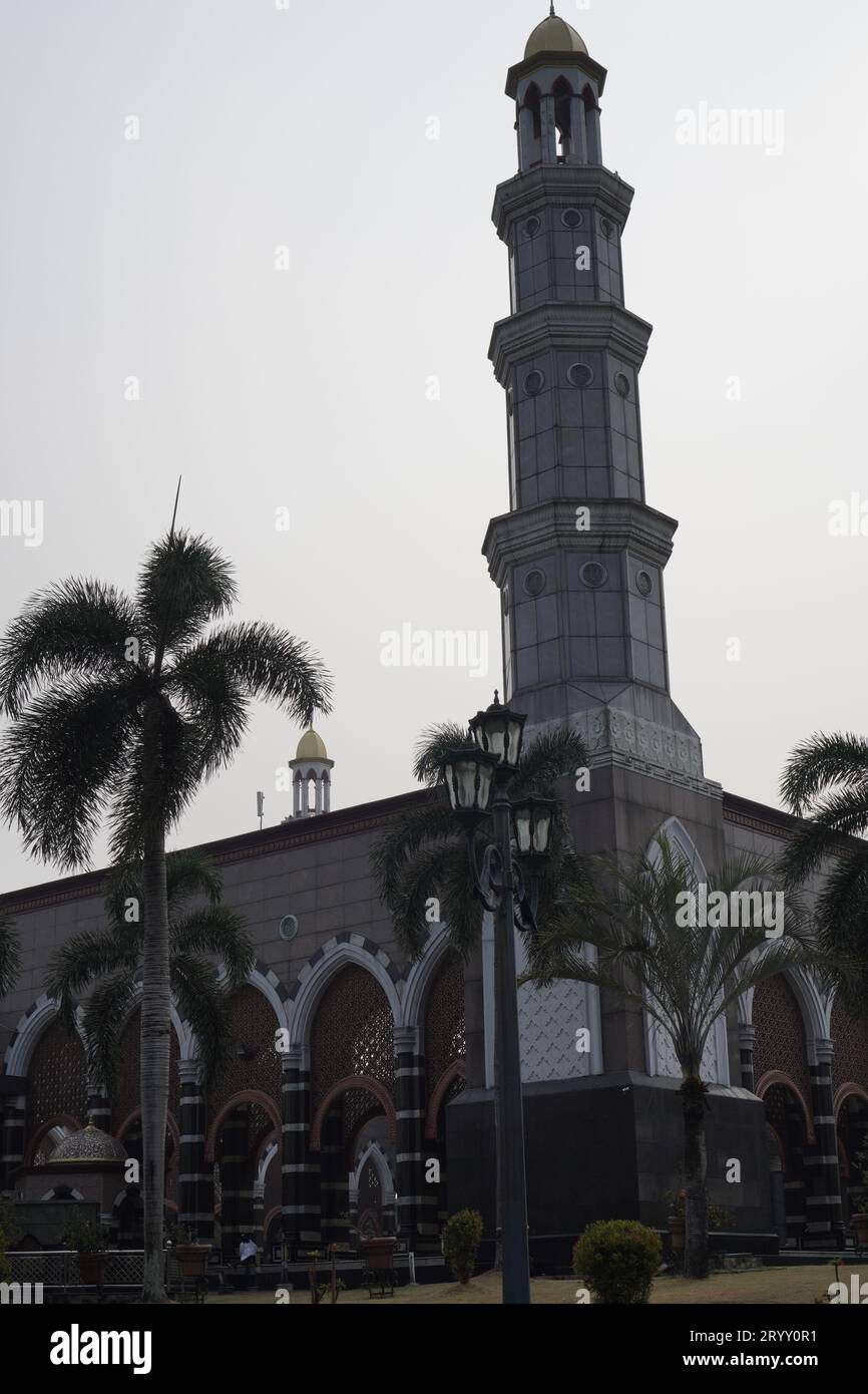 La bella torre della moschea è verde, con luci da giardino. sfondo cielo nel pomeriggio. Foto Stock