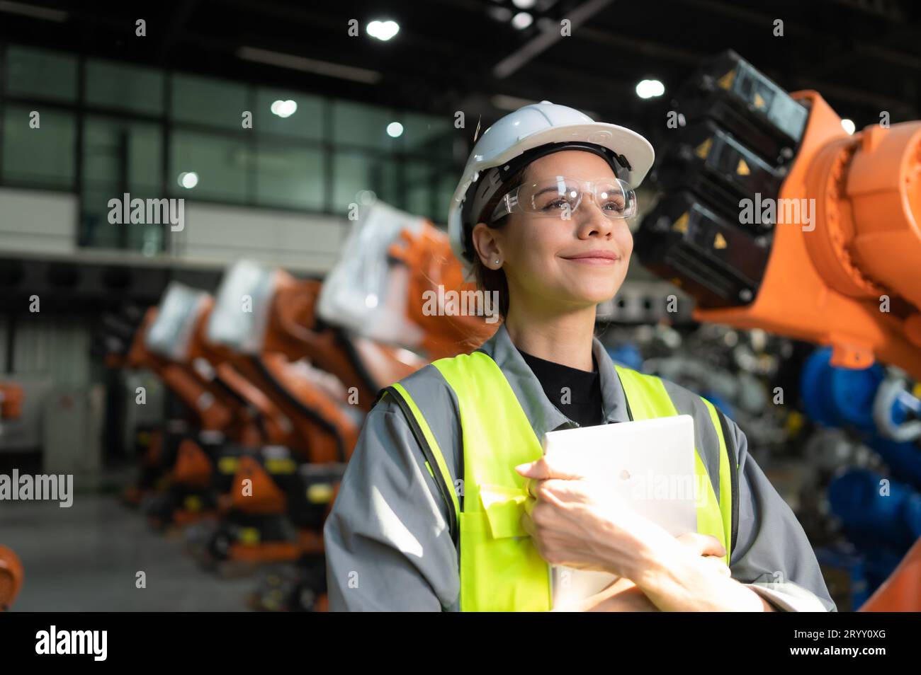 Ritratto di una donna ingegnere con la missione di controllare, testare, migliorare il software e calibrare il braccio robotico. Foto Stock