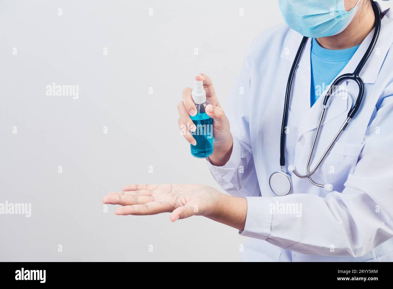 Doctor spruzza disinfettante per le mani o dispenser di gel per pulire le mani e uccidere virus e batteri ai pazienti come esempio. Guarigione medica Foto Stock