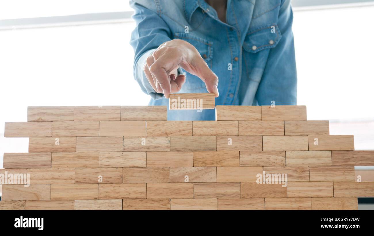 Gruppo di amici che giocano blocchi di legno gameÂ sul tavolo piegato puzzle tenendo blocchi di legno gioco pianificazione rischio e strategia in autobus Foto Stock