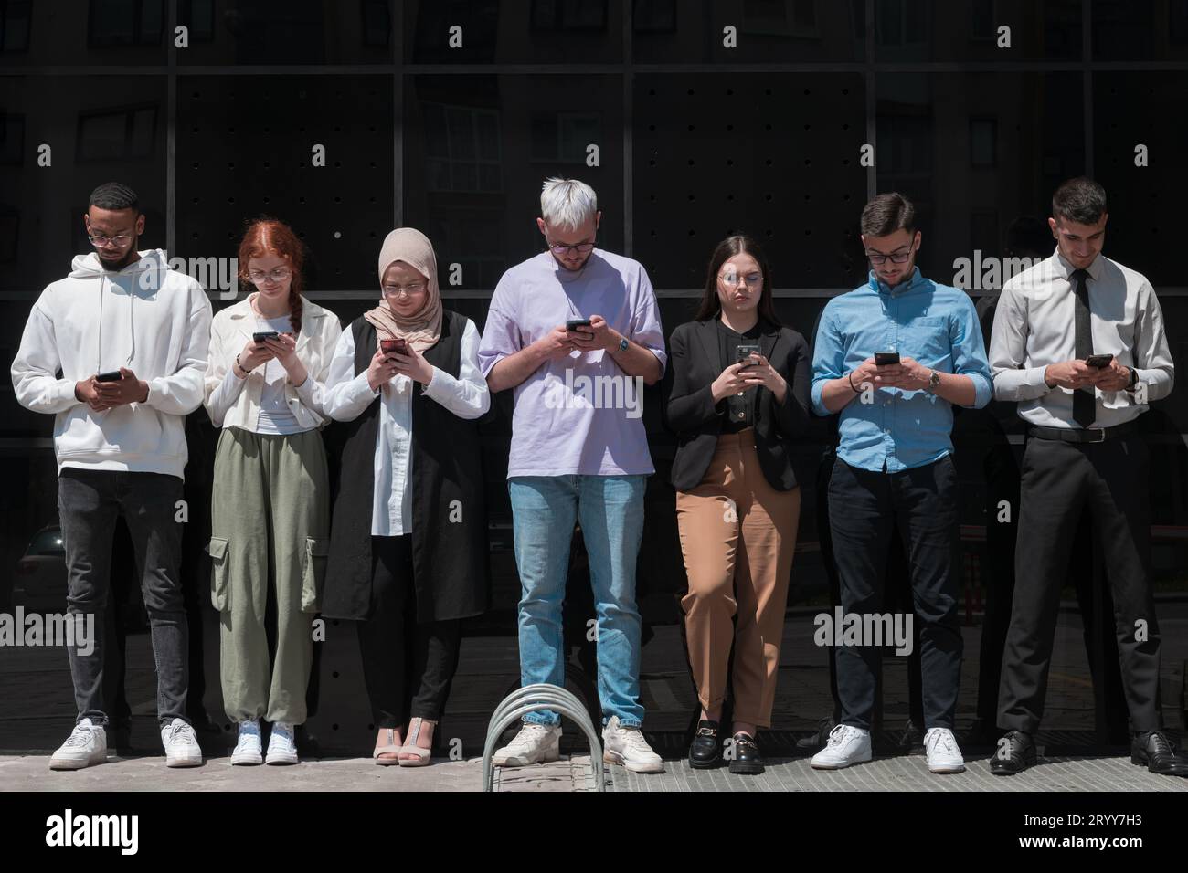 Un gruppo eterogeneo e fiducioso di giovani uomini d'affari si pone insieme, irradiando successo, ambizione e unità, catturando l'essenza Foto Stock