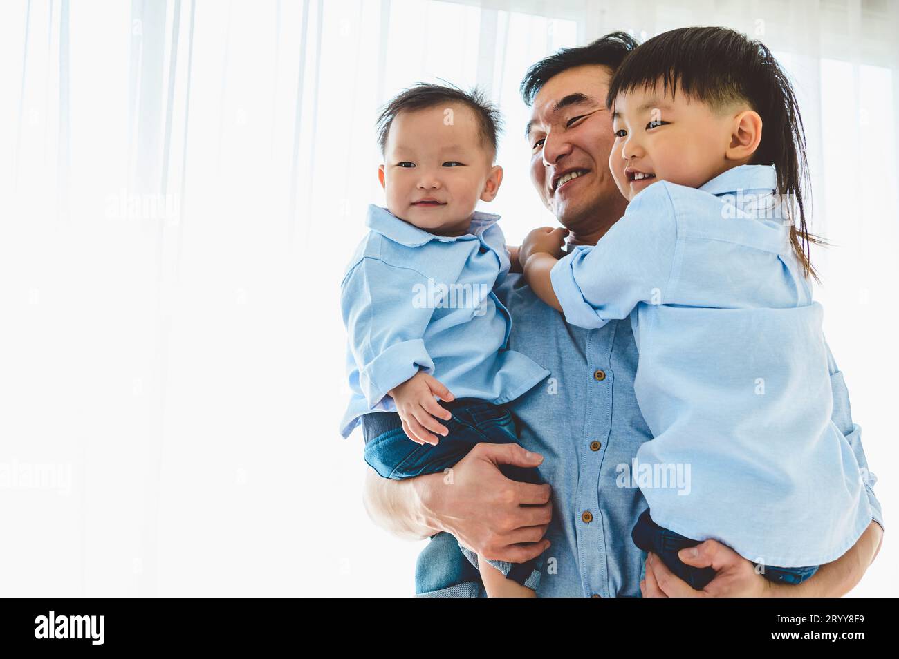 Padre felice che porta due bambini in camera da letto a casa loro. Vivere in famiglia e avere un'espressione positiva emozione insieme. Foto Stock