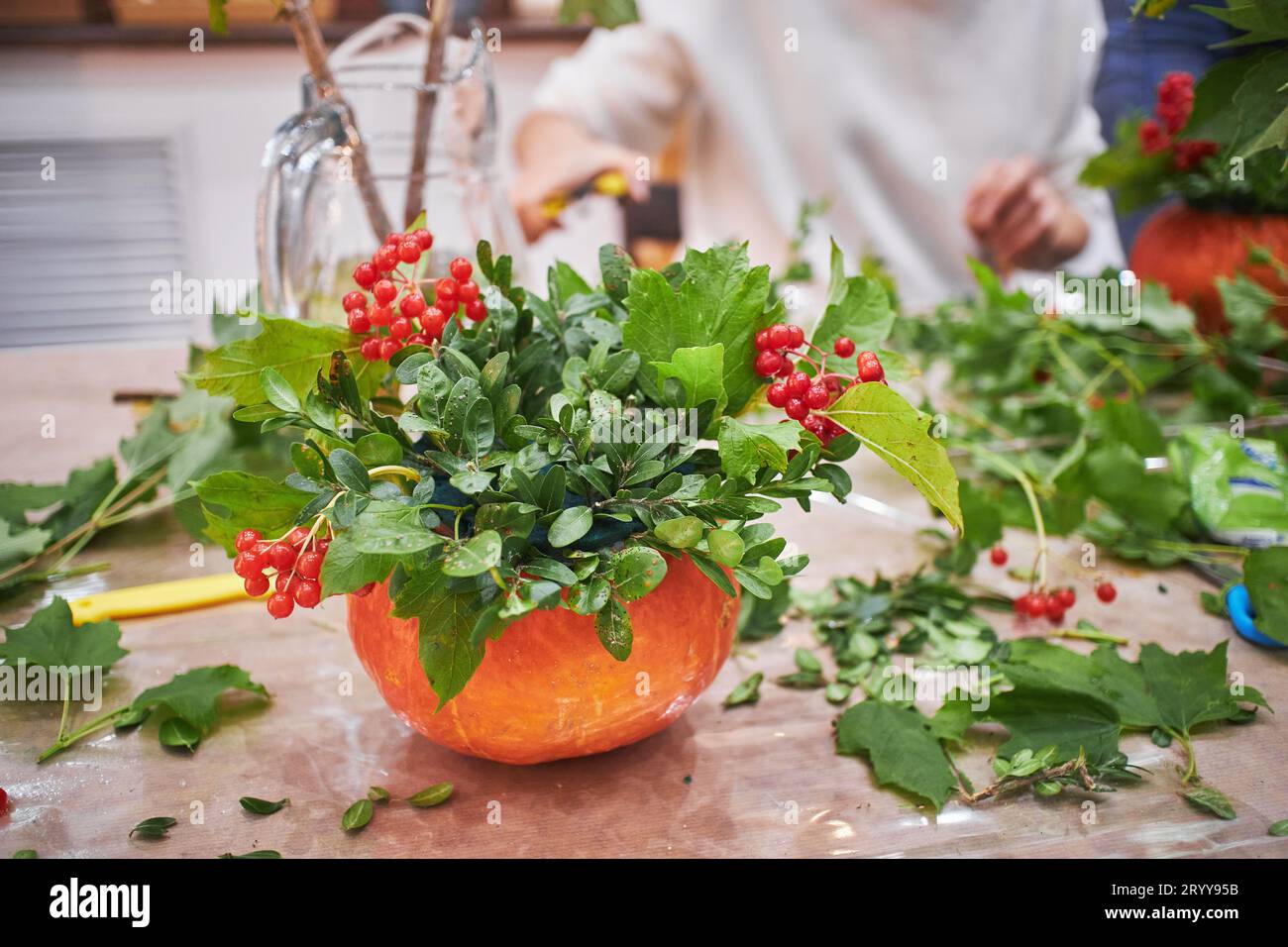 Master class sulla preparazione dei mazzi d'acqua. Bouquet autunnale in una zucca. Composizioni floreali che creano splendidi mazzi con il tuo han Foto Stock