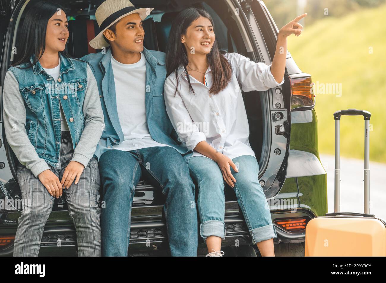 Uomini e donne asiatici che si rilassano sul retro del bagagliaio durante i viaggi estivi. Concetto di trasporto e stile di vita delle persone. Gruppo o Foto Stock