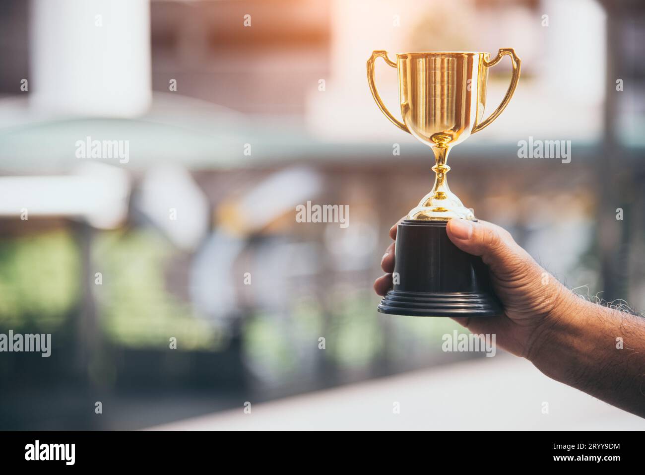 Trofeo d'oro campione per il vincitore sullo sfondo della mano. Concetto di successo. Tema sport e coppa premio. Miglior business entr Foto Stock