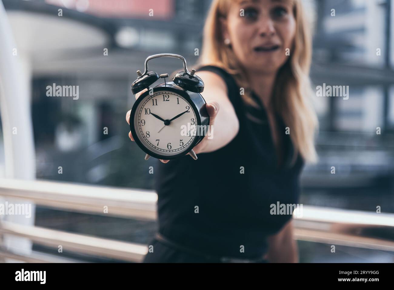 Le donne d'affari mostrano la sveglia e sono scioccate dalle ore di punta tarde quando vanno a lavorare in città. Deadline e wa Foto Stock