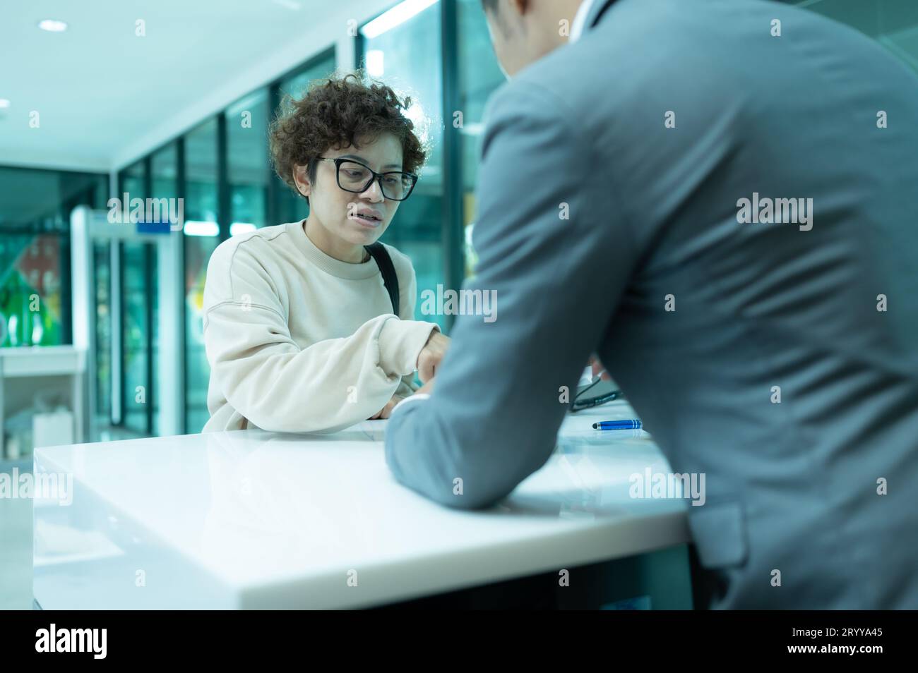 Il personale di terra della compagnia aerea aiuta i passeggeri a controllare i biglietti e i passaporti per il viaggio. Foto Stock