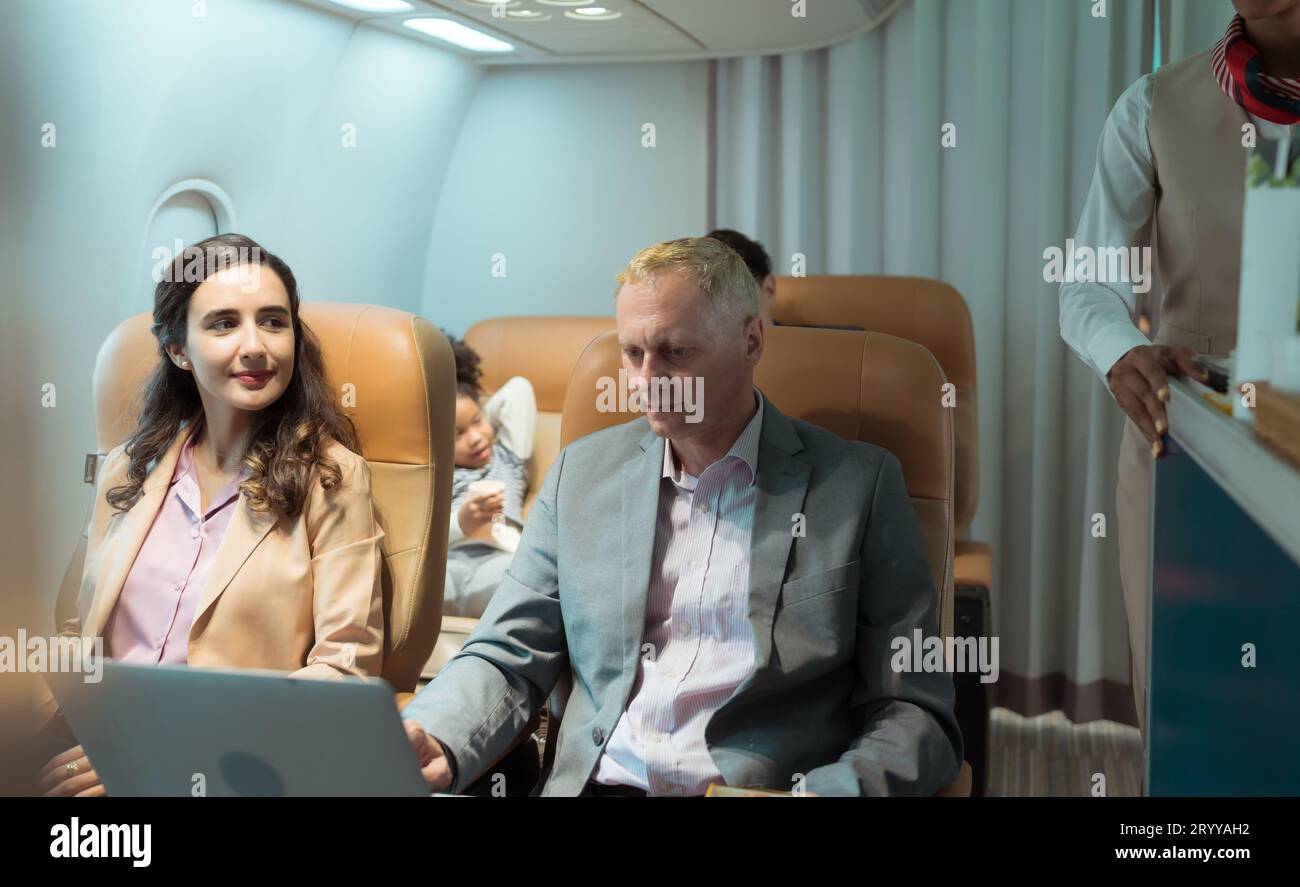 Assistente di volo che serve cibo e bevande ai passeggeri Foto Stock
