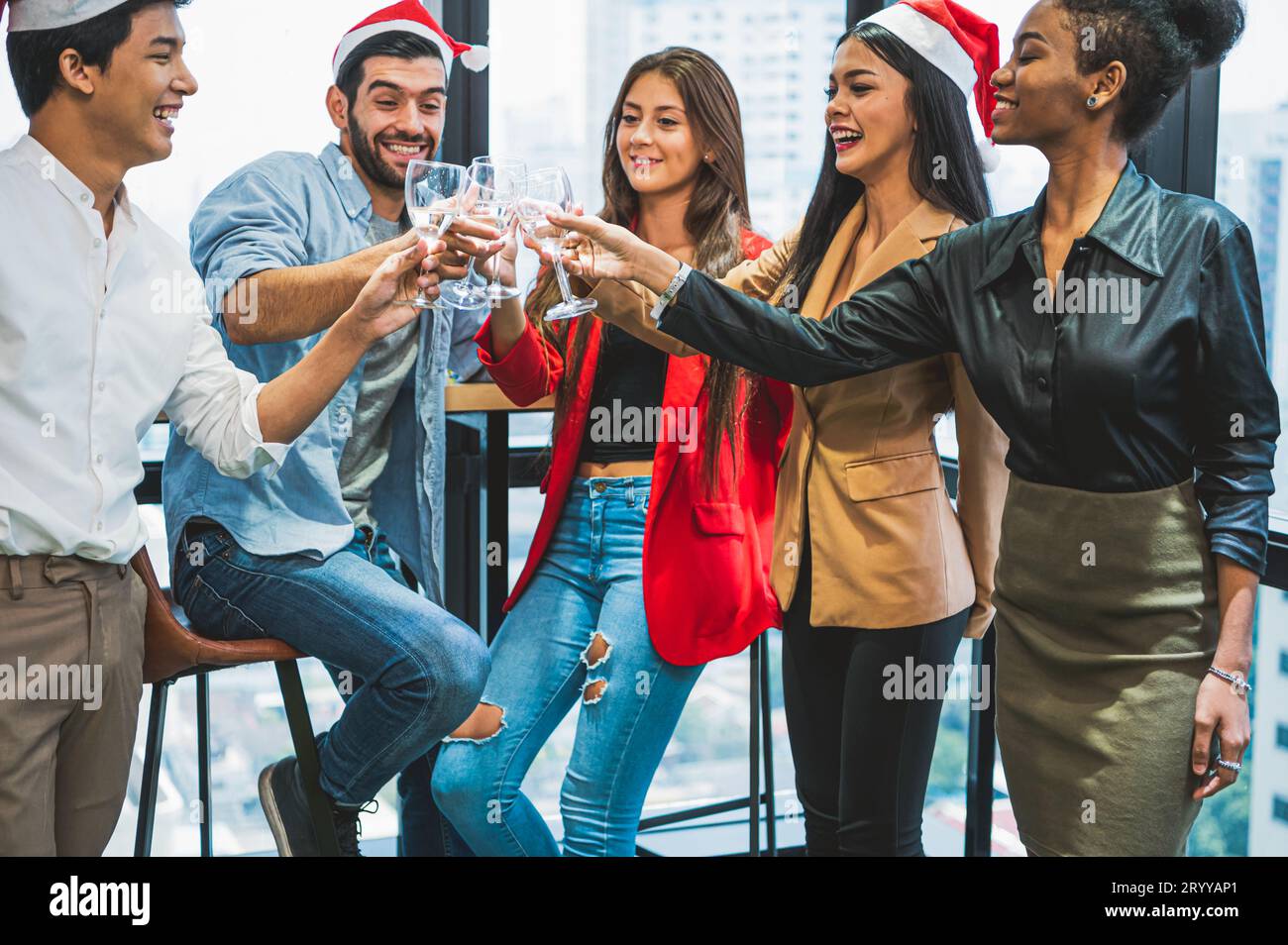 Gruppo di lavoro di gruppo Diversity collega che festeggia la festa di Capodanno in un moderno contesto urbano di uffici. Amici che hanno e Foto Stock