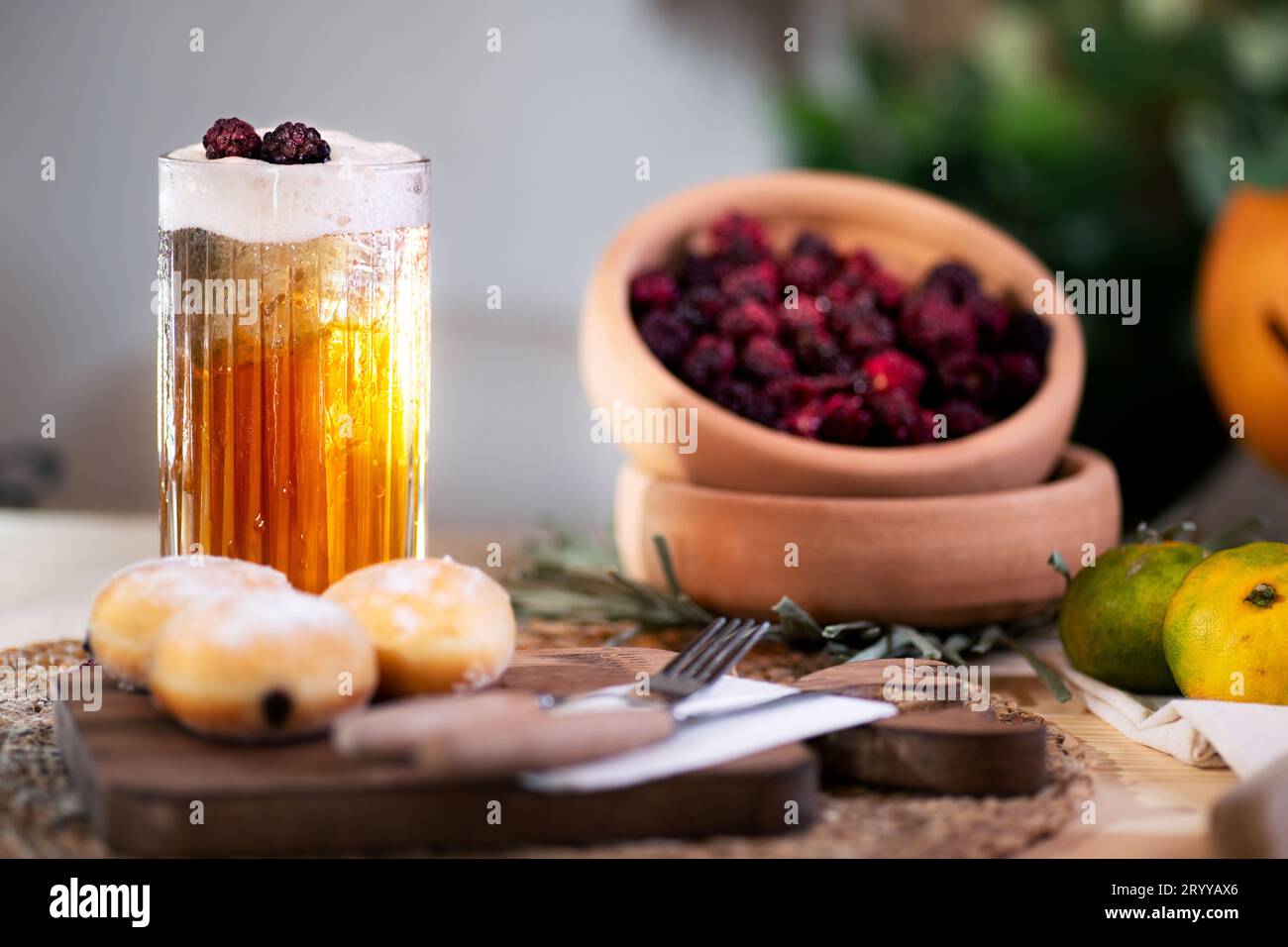 Incentrato su spugna di mela condita con tre more, circondato da un biscotto pieno di cioccolato, posate, mandarini e una jack o'lantern. Foto Stock